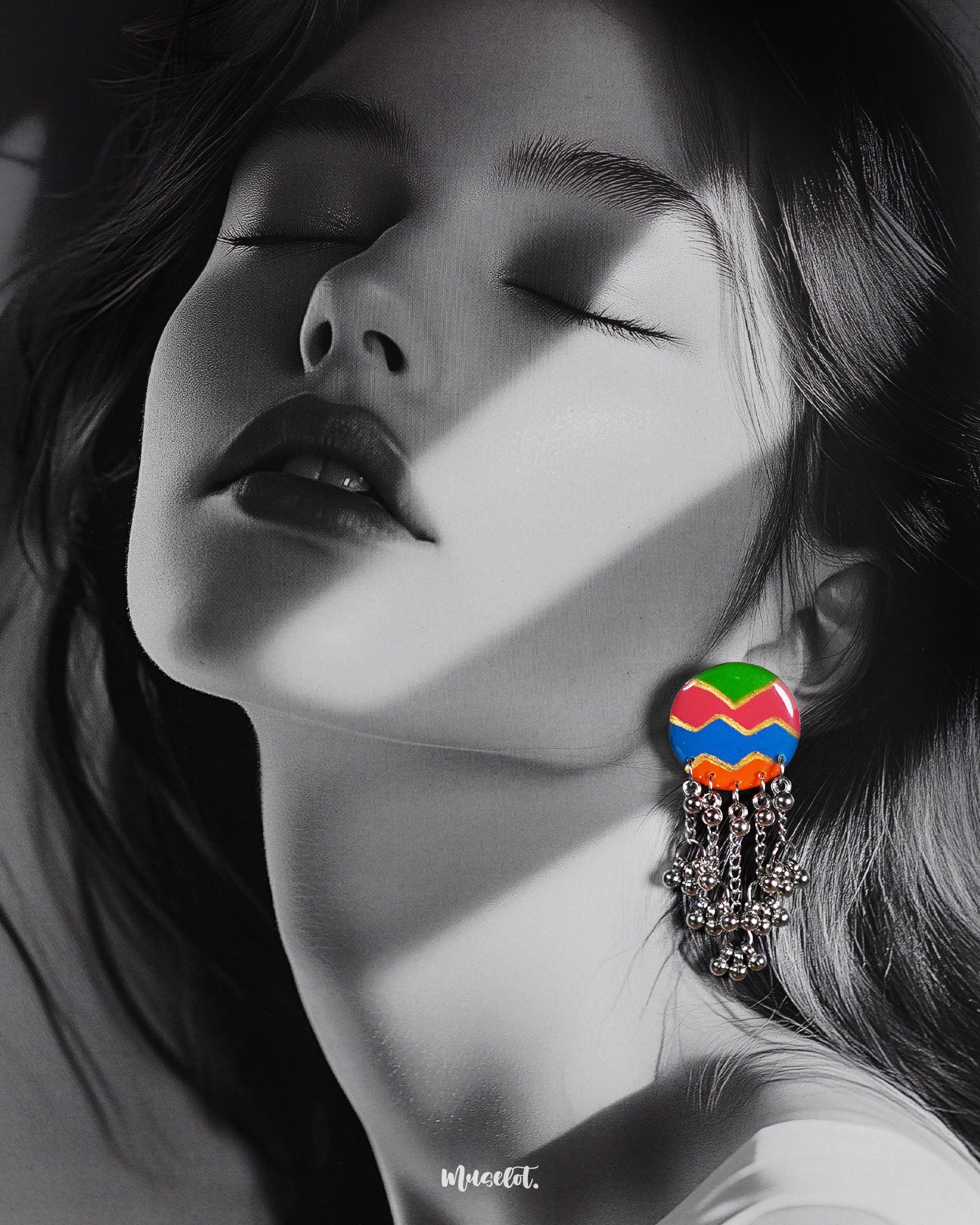 A woman wearing the Rangtarang chain earrings, styled with effortless charm as the vibrant zigzag-patterned tops in green, pink, blue, and orange pop against her look, while the dangling silver bead chains add playful movement and ethnic flair – Muselot.