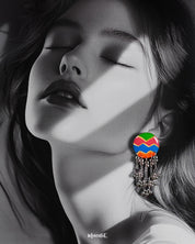 A woman wearing the Rangtarang chain earrings, styled with effortless charm as the vibrant zigzag-patterned tops in green, pink, blue, and orange pop against her look, while the dangling silver bead chains add playful movement and ethnic flair – Muselot.