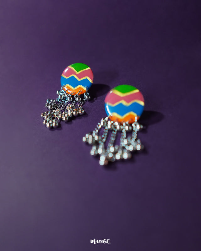 A close-up of the Rangtarang colorful long chain earrings, featuring delicate painted motifs in vibrant hues with playful beadwork, exuding artisanal flair and festive elegance – Muselot.