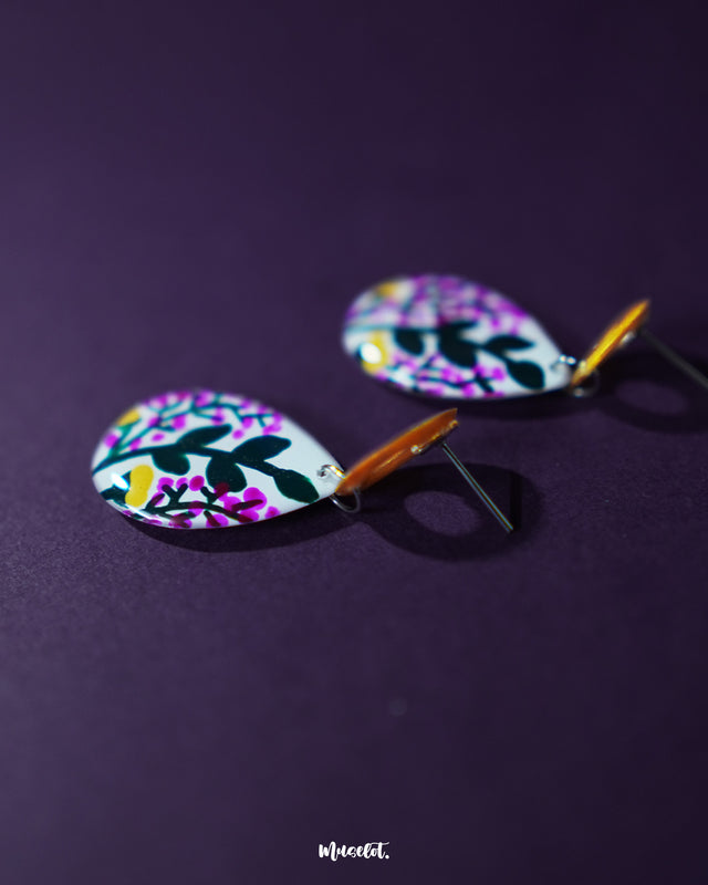 Raushanbahaar floral drop earrings featuring vibrant pink and yellow flowers with green leafy details on a teardrop silhouette, highlighting their vivid colors and showcasing the playful elegance of handcrafted statement pieces — Muselot.