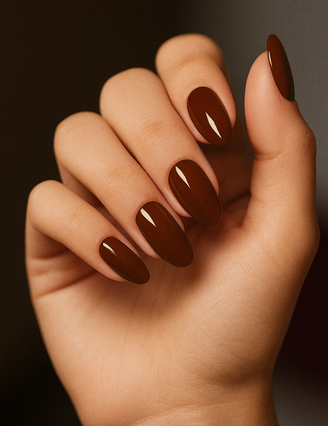 A shot of a model’s hand wearing Rich Cocoa nail stickies, showcasing the deep chocolate-brown shade with a sleek glossy finish, highlighting the bold yet elegant charm of minimal nail art in a refined salon-style look – Muselot.