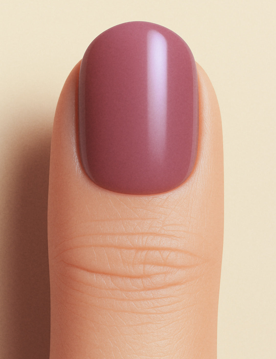A closeup shot of a model thumb, showcasing a rich mauve shade with a glossy finish, highlighting the elegance of minimal solid color nails-Muselot