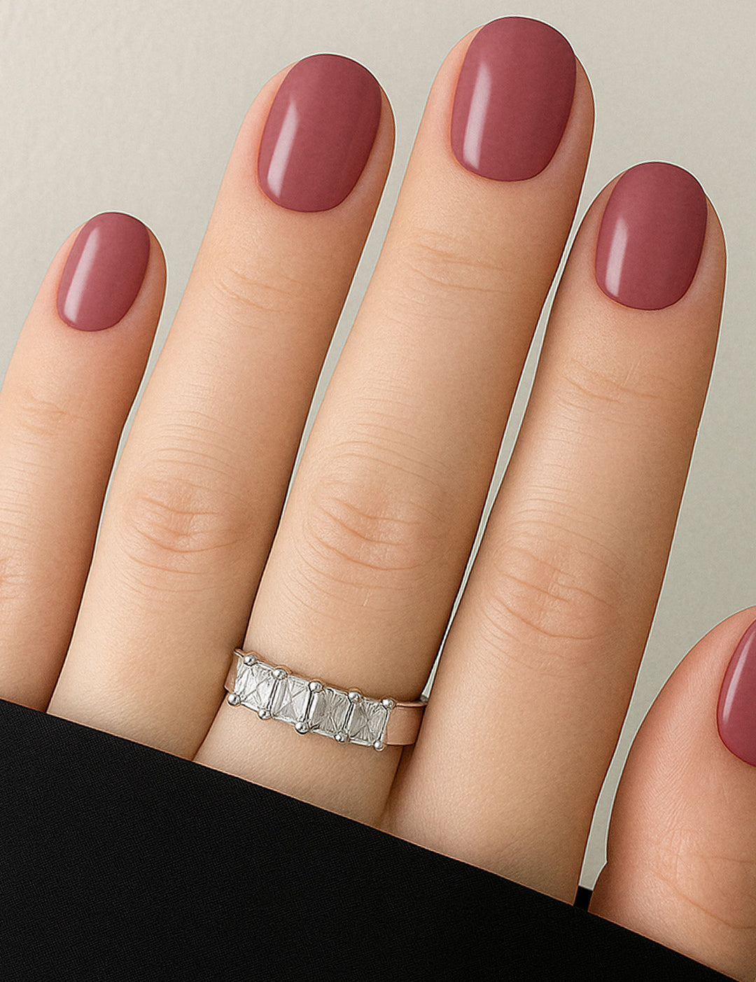 A shot of a model’s hand wearing Rose Clay nail stickies, showcasing the shade in a rich mauve tone with a glossy solid finish, highlighting the elegance of minimal nail art while adding a refined salon-style look – Muselot.