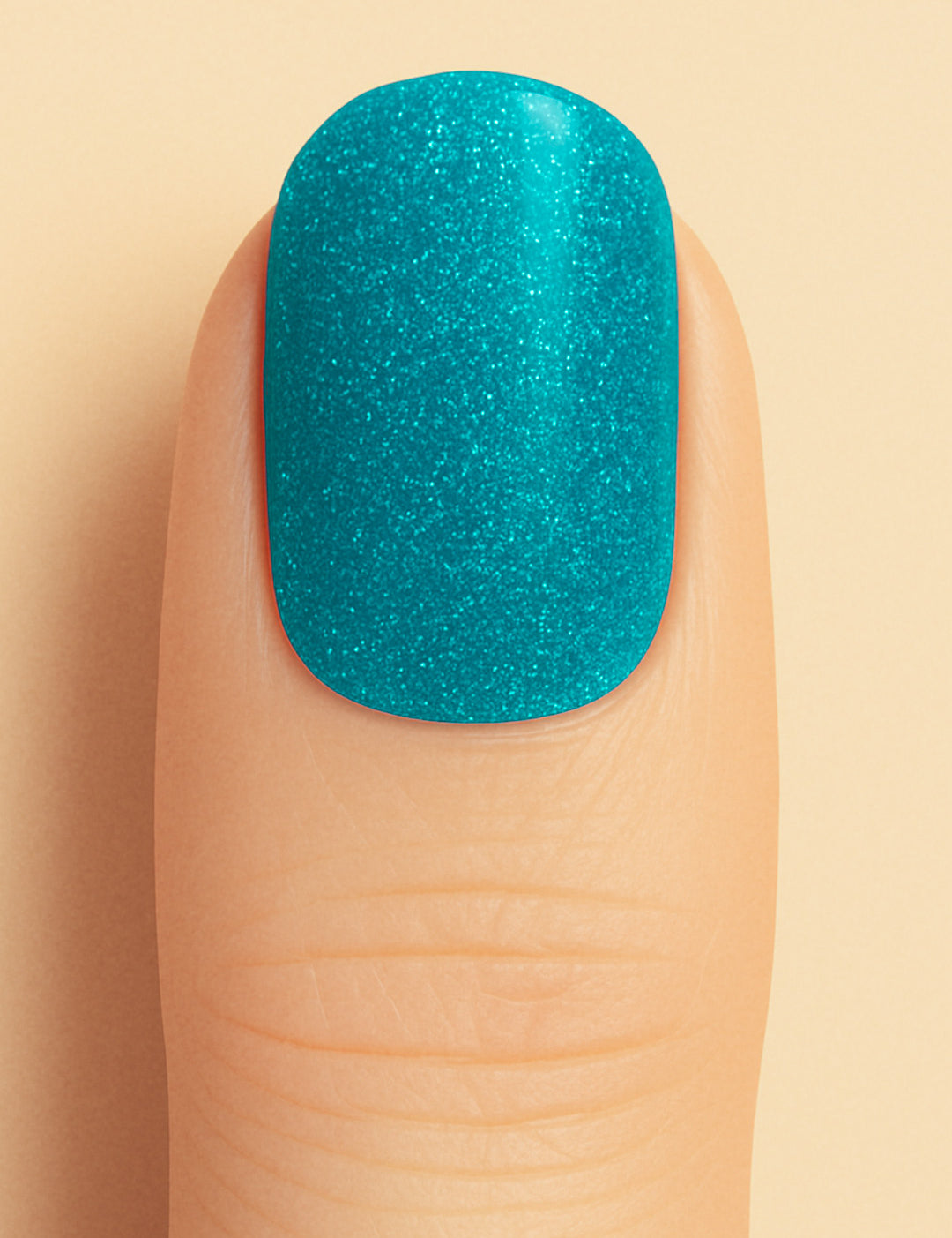 A close-up shot of a model’s finger wearing Sea Spark Glitter nail stickies, showcasing the bright turquoise-blue shade packed with fine glitter shimmer, highlighting the bold sparkle and vibrant charm of glitter nail art with a smooth glossy finish – Muselot.