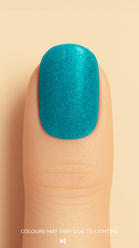 A close-up shot of a model’s finger wearing Sea Spark Glitter nail stickies, showcasing the bright turquoise-blue shade packed with fine glitter shimmer, highlighting the bold sparkle and vibrant charm of glitter nail art with a smooth glossy finish – Muselot.