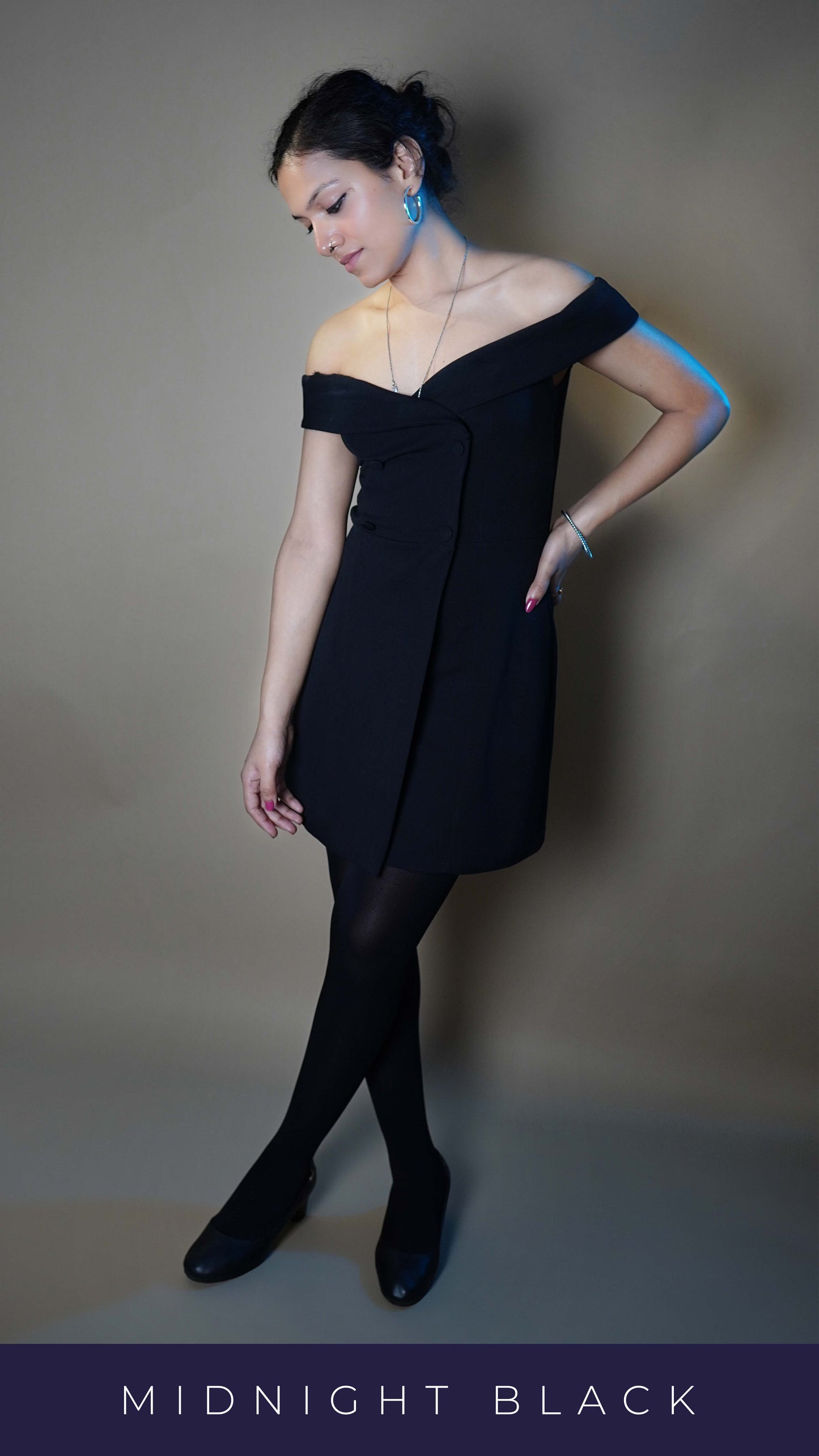 A woman wearing black comfortable no tear stockings, posing with her hand hanging at her front and other on her waist as her leg crosses the other, highlighting a stylish perfect fit-Muselot