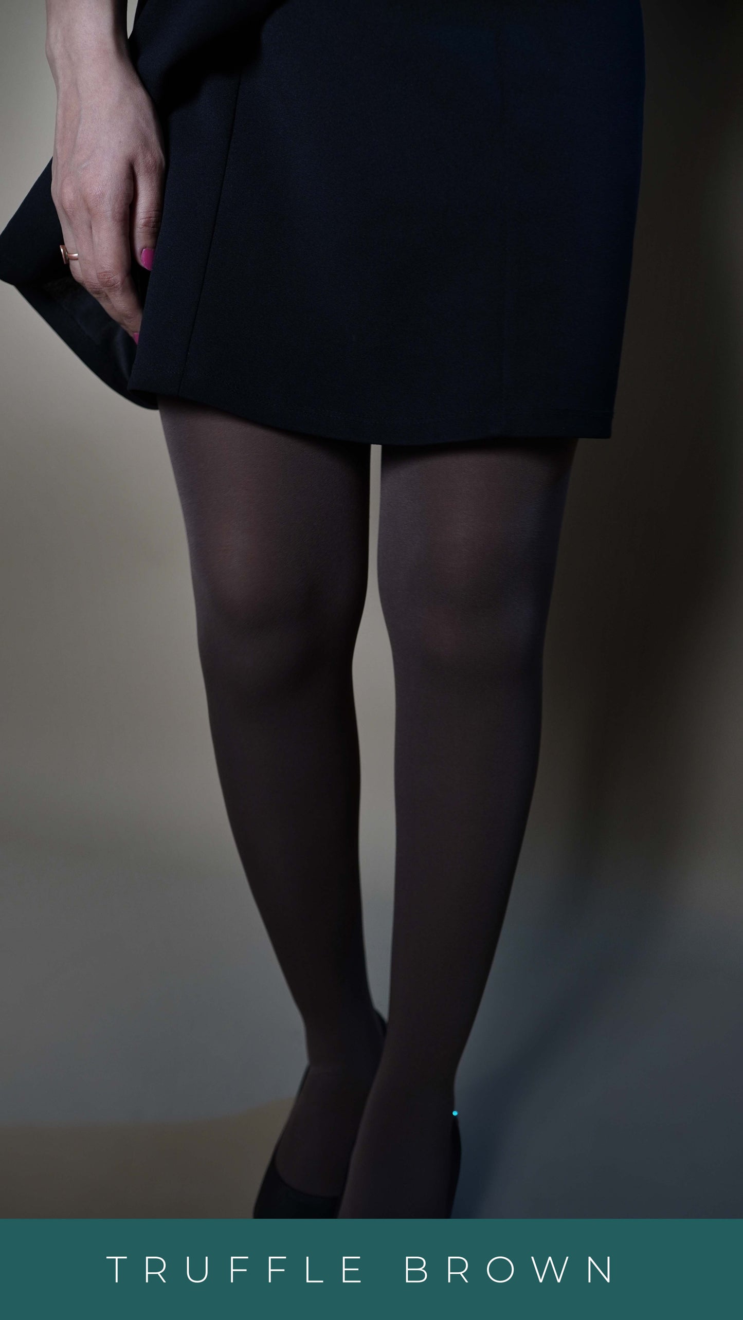 A lower half picture of a model wearing semi opaque stretchable tights paired with a black dress, posing with her hand hanging on her side, showcasing the stretchable comfortable material-Muselot