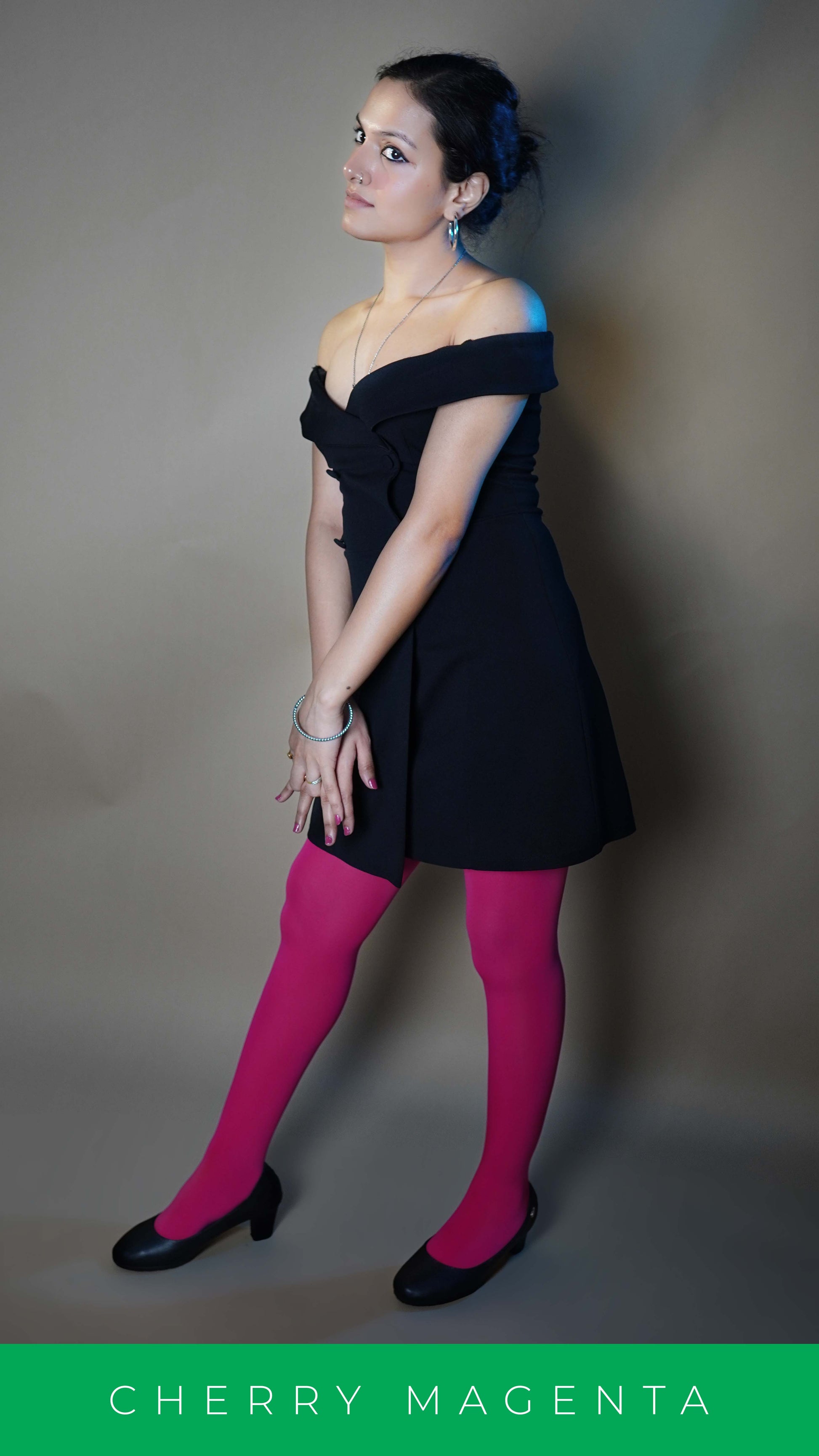 A woman wearing semi opaque tear proof hot pink stocking, posing with her hands crossed at her front as she stands slightly sideways, showcasing the durable comfortable fit-Muselot