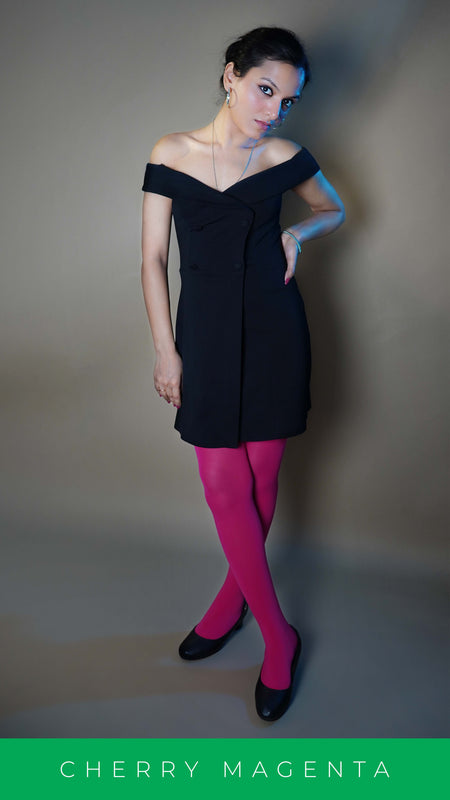 A woman wearing tear proof hot pink females stocking, posing with her hand hanging at her side and other on her waist as she stands with crossed legs, highlighting the relaxed modern look-Muselot