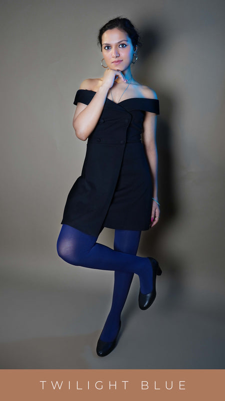 A woman wearing navy blue tear resistant comfortable tights, posing with her fingers under her chin as her other hand hangs at her side with a leg pulled up and bent towards her knee, showcasing the tear proof durable material-Muselot