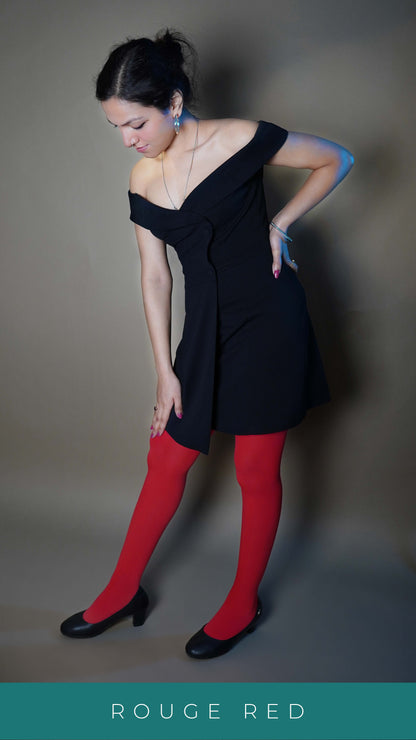 A woman wearing semi opaque tear proof red stockings, posing with her on her waist and other touching her knee as she bends slightly forward, showcasing the colored smooth material-Muselot