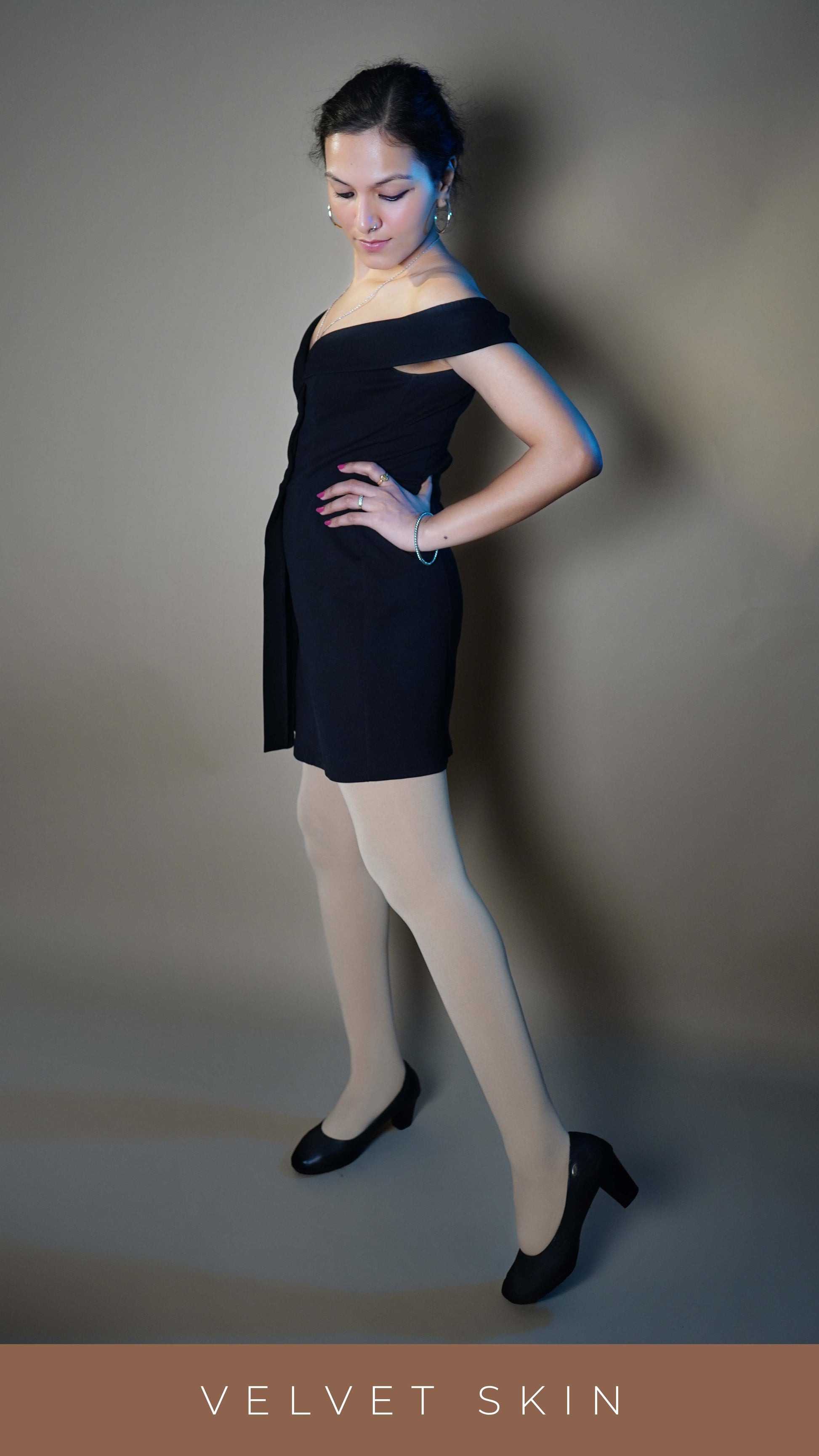 A women wearing moisture wicking semi opaque beige stockings, posing with her hand on her waist and leg stretched at her side as she stands sideways, showcasing the smooth durable material-Muselot