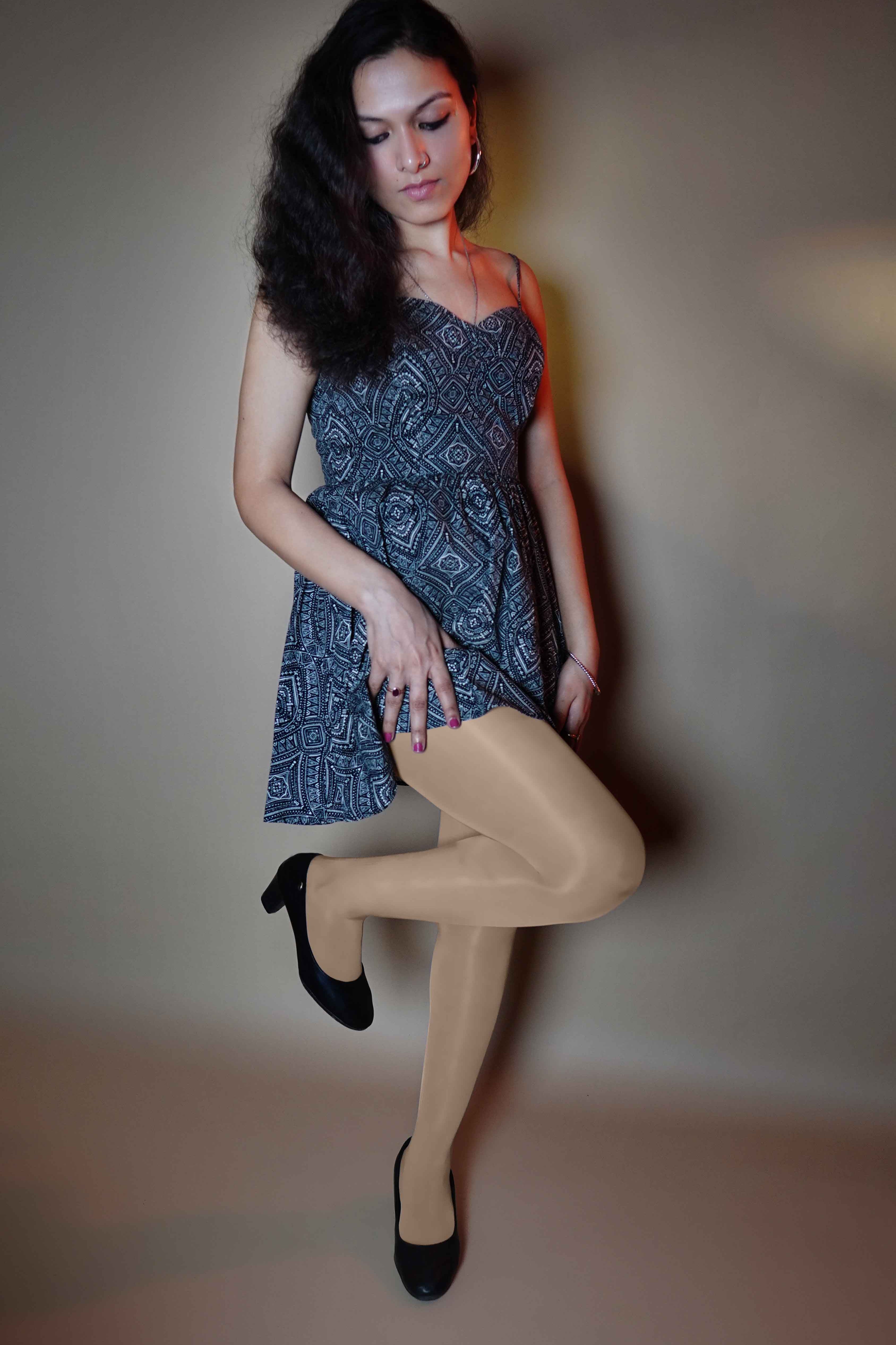 A model posing with her leg bent forward and her hand on her thigh, wearing silken touch plus size sheer stockings, showcasing the no tear smooth look-Muselot