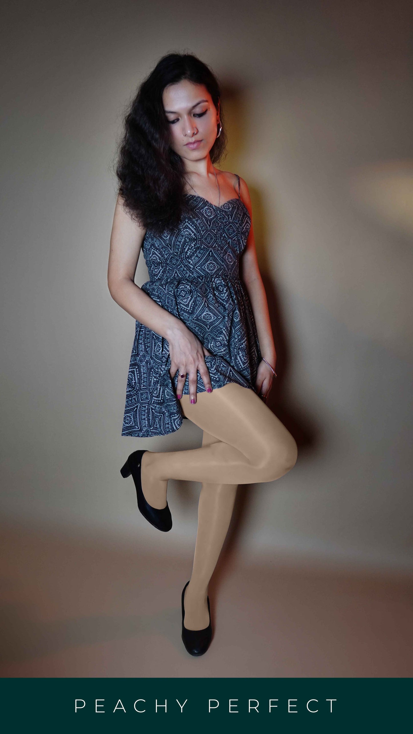 A model posing with her leg bent forward and her hand on her thigh, wearing silken touch plus size sheer stockings, showcasing the no tear smooth look-Muselot