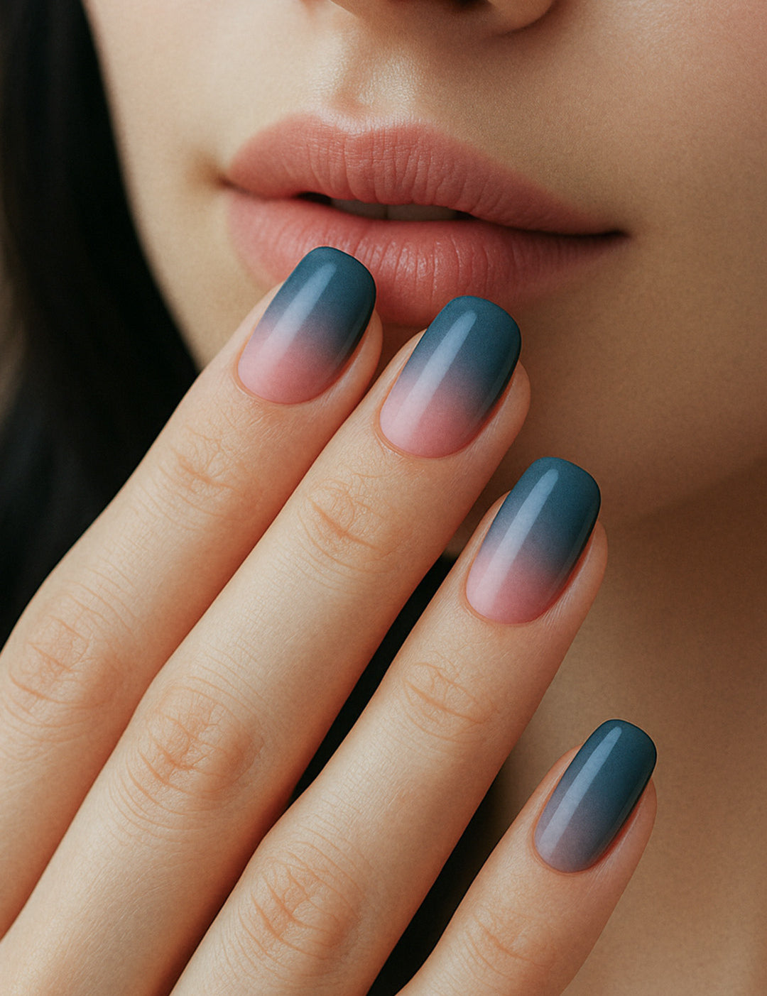 A model’s hand showcasing Twilight Rose Ombre nail stickies, featuring a chic gradient blend from deep teal-blue to soft blush pink, highlighting the smooth ombre transition and glossy salon-style finish – Muselot.