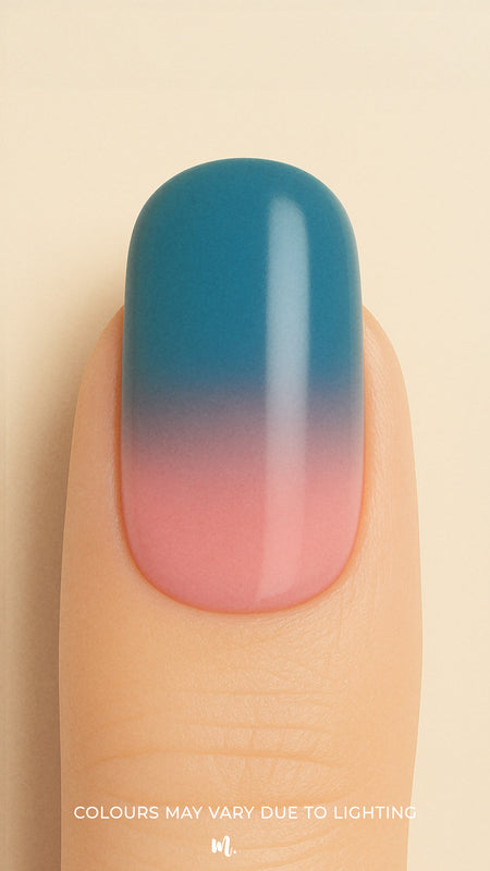 A close-up shot of a model’s finger wearing Twilight Rose Ombre nail stickies, showcasing the seamless transition from a muted rose pink at the base to a deep teal-blue at the tip, highlighting the modern elegance and smooth glossy finish of gradient nail art – Muselot.