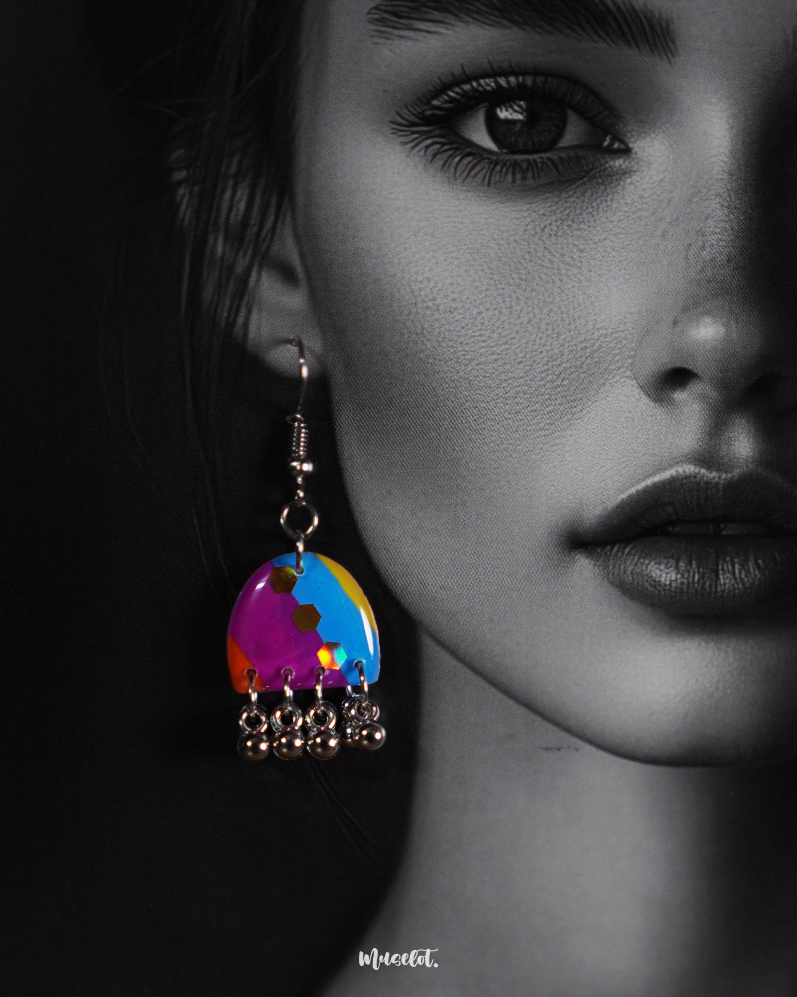 Close-up shot of a model wearing Ufaq multicolor earrings, with vivid shades and bold patterns that stand out against the soft lighting, showcasing their unique design and vibrant allure — Muselot.