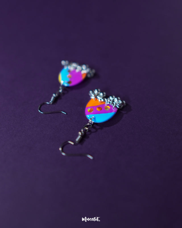 Ufaq multicolor hook earrings, set against a rich purple background, featuring a burst of colors and unique geometric shapes that highlight the earrings' lively and sophisticated charm — Muselot.