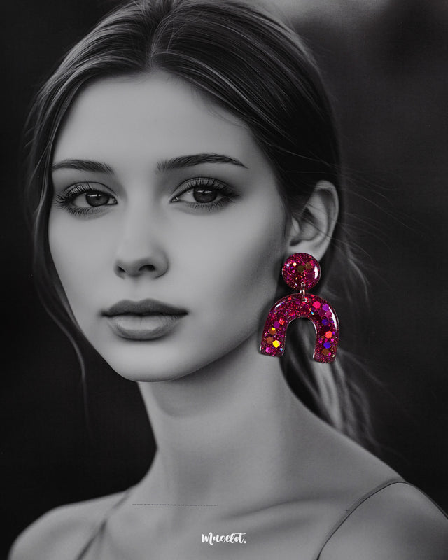 Model wearing Ulfat glitter resin stud earrings in bold pink-purple sparkle, styled to showcase their statement arch design and vibrant shine – Muselot.