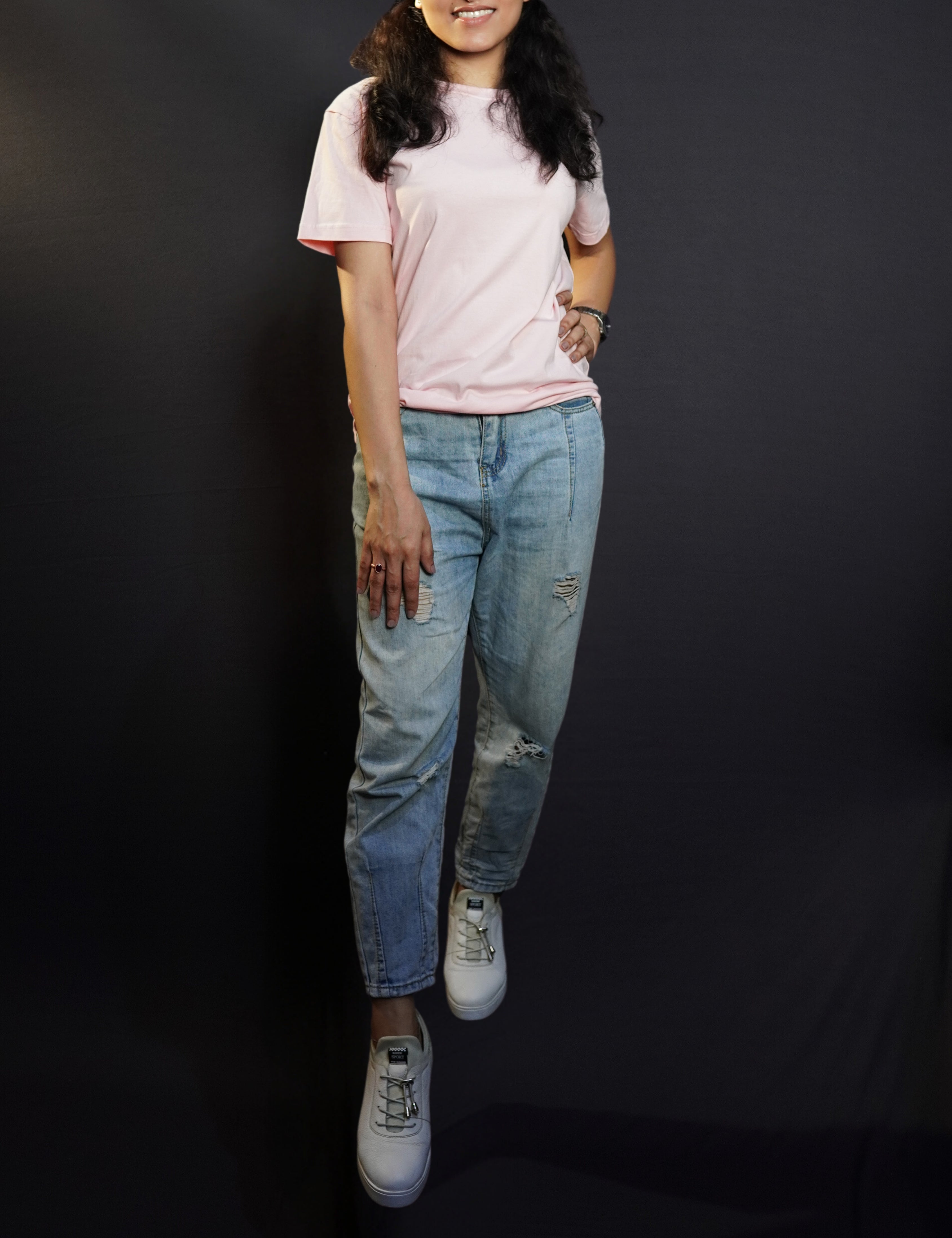 A beautiful model confidently poses against a dark background, wearing a casual, plain round-neck t-shirt with half sleeves,  highlighting a modern relaxed fit-muselot