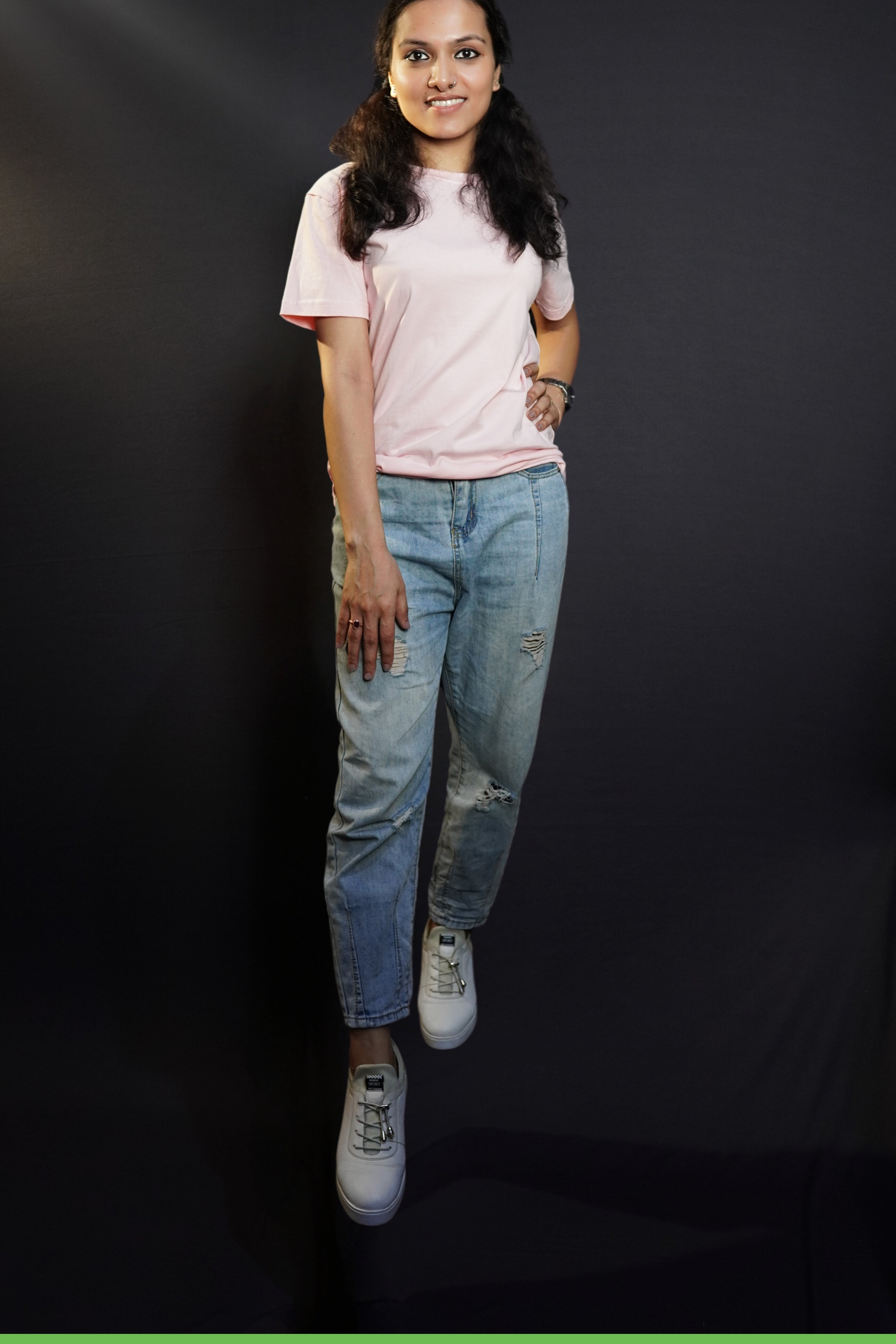 A beautiful model confidently poses against a dark background, wearing a casual, plain round-neck t-shirt with half sleeves,  highlighting a modern relaxed fit-muselot
