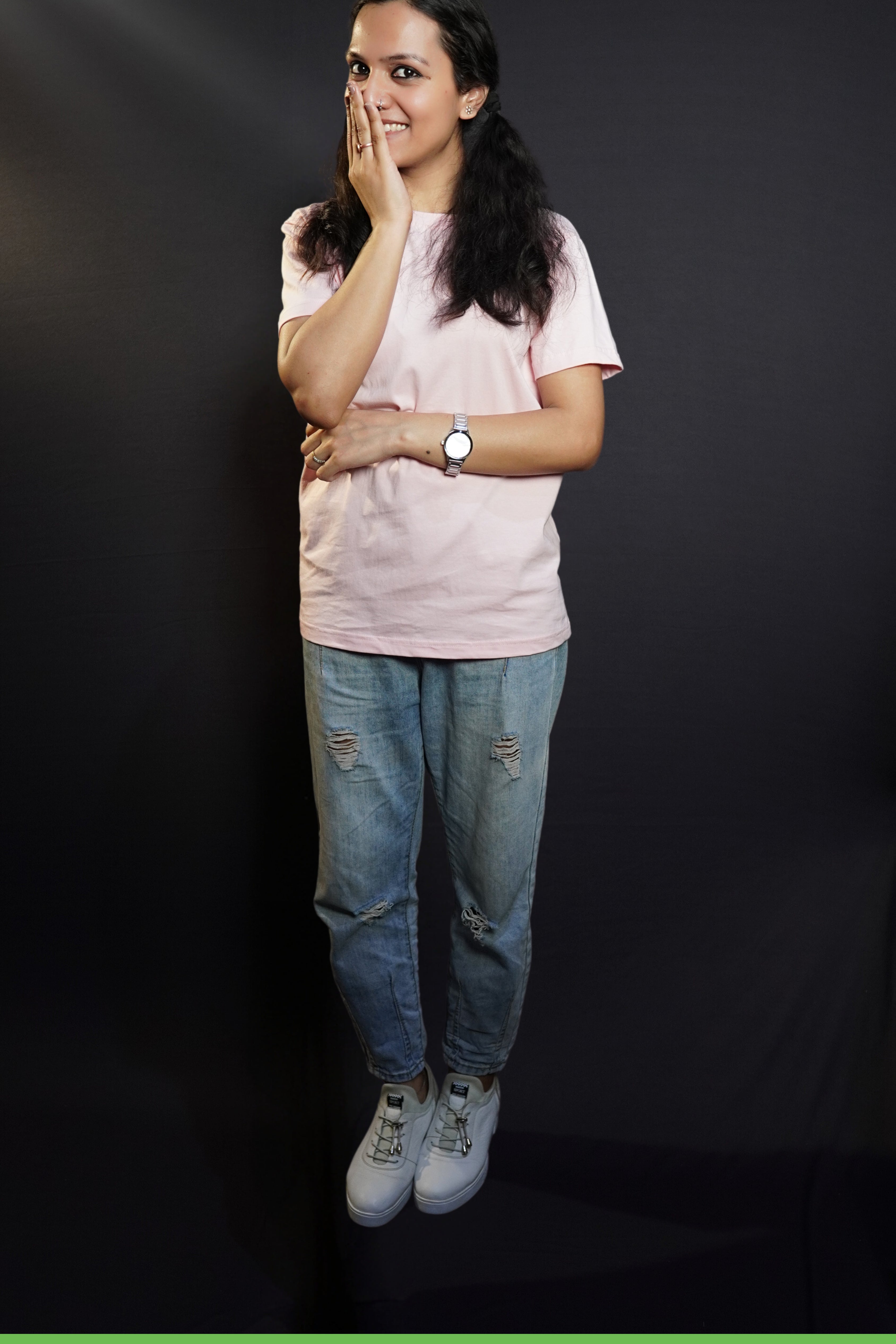 A young model wearing a blush pink unisex t shirt with a simple, short-sleeved design, pairing the top with ripped blue jeans, highlighting a casual, everyday look-muselot
