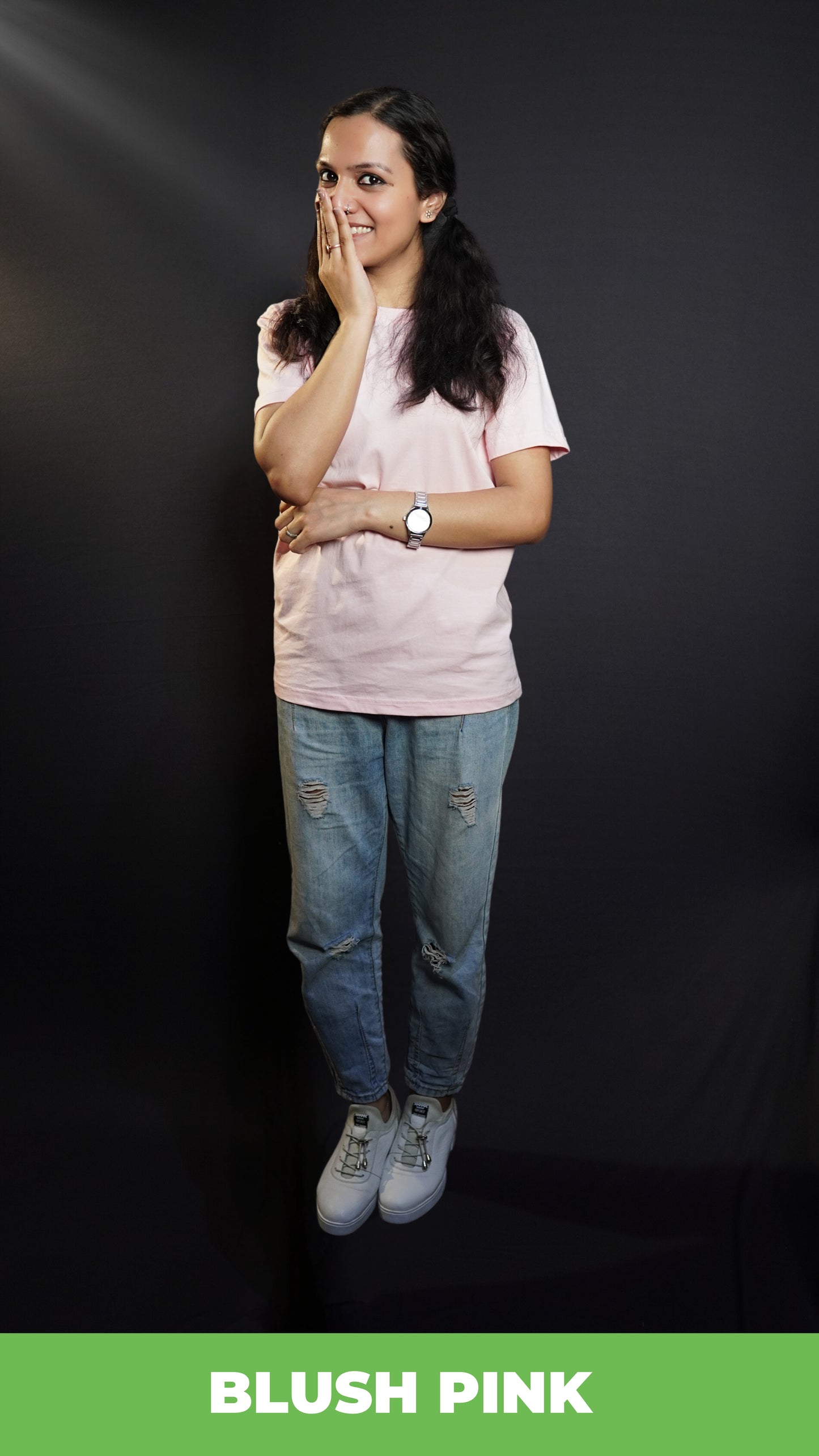 A young model wearing a blush pink unisex t shirt with a simple, short-sleeved design, pairing the top with ripped blue jeans, highlighting a casual, everyday look-muselot