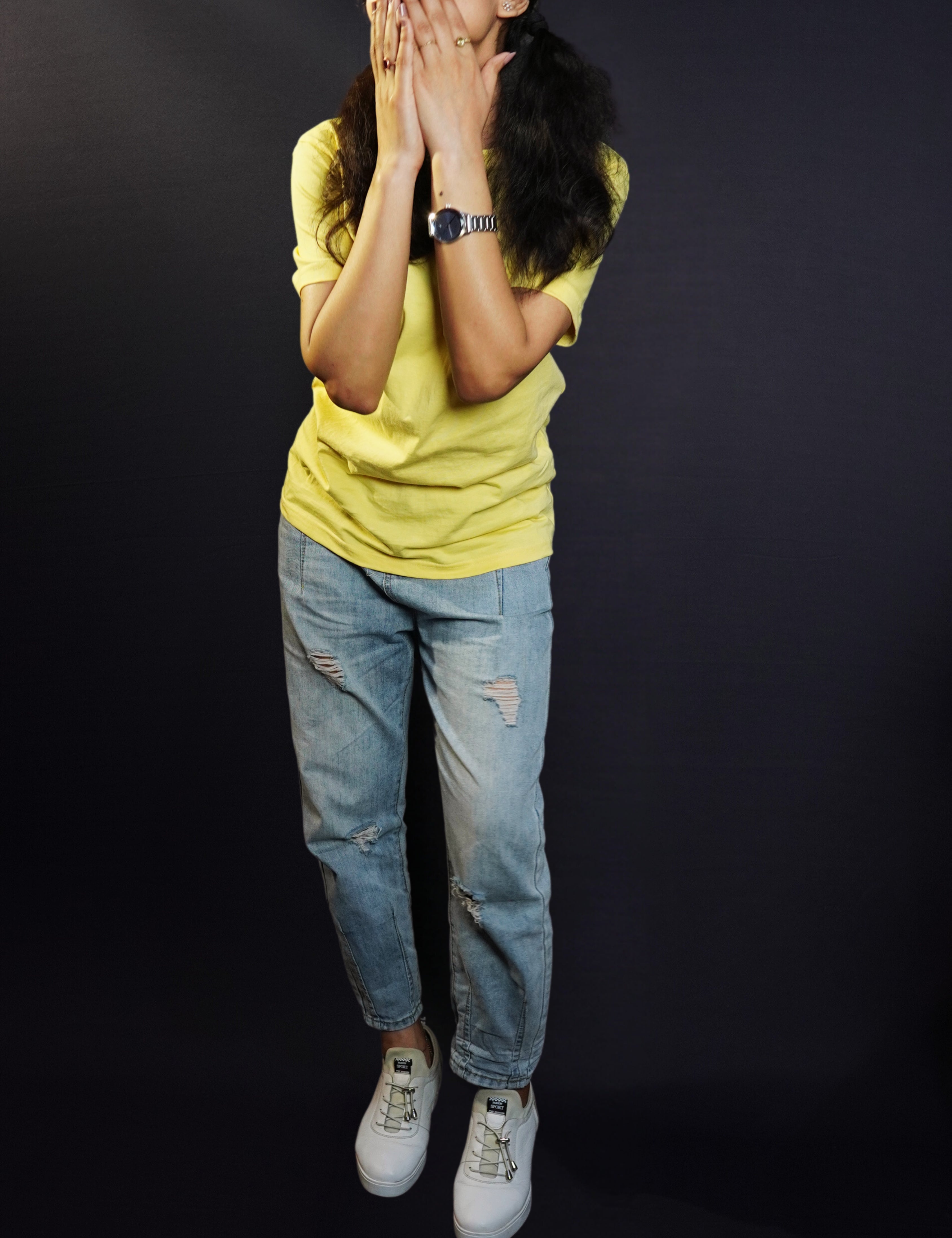 A woman wearing a half sleeved plain round neck sweat resistant butter yellow t-shirt, posing with her hands covering her mouth, highlighting an informal fresh look-Muselot