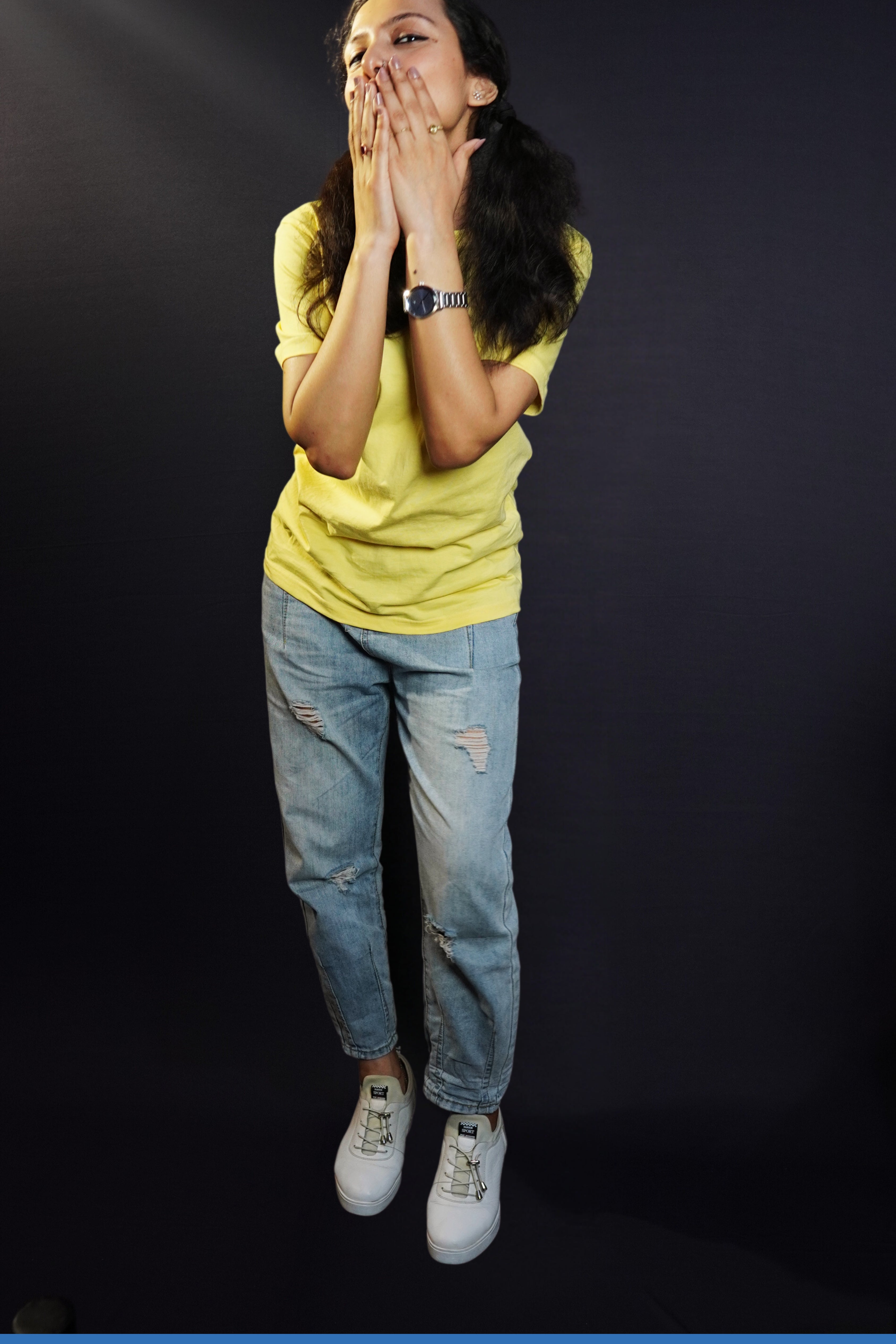 A woman wearing a half sleeved plain round neck sweat resistant butter yellow t-shirt, posing with her hands covering her mouth, highlighting an informal fresh look-Muselot