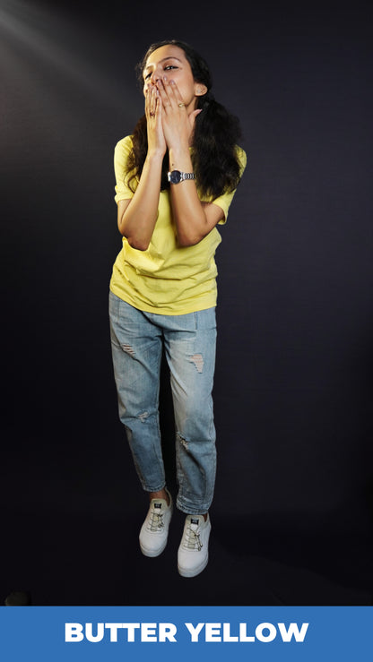 A woman wearing a half sleeved plain round neck sweat resistant butter yellow t-shirt, posing with her hands covering her mouth, highlighting an informal fresh look-Muselot