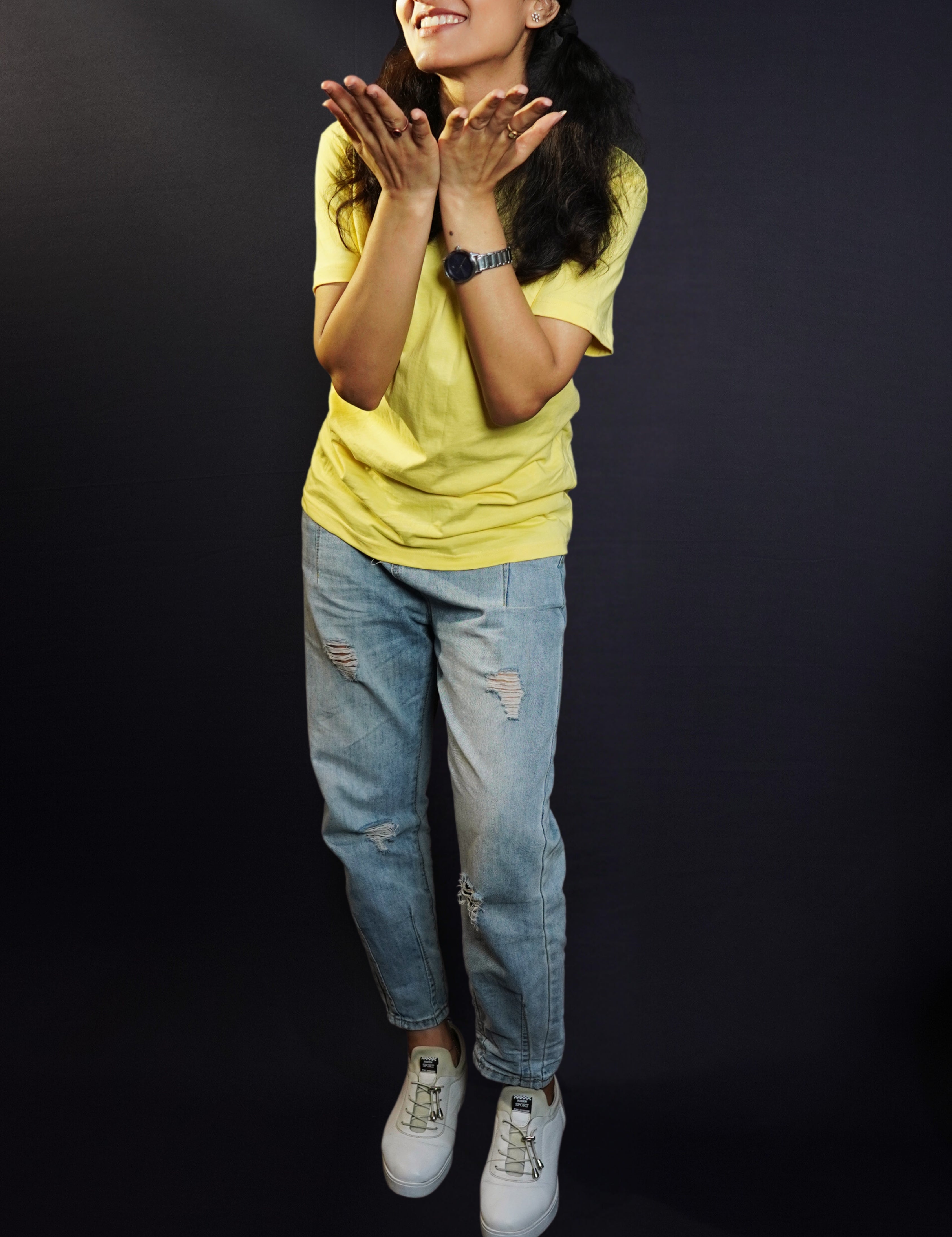 A woman posing happily with her hands directing forward, wearing a long length round neck plain adult's t-shirt, highlighting an elegant drapye look-Muselot
