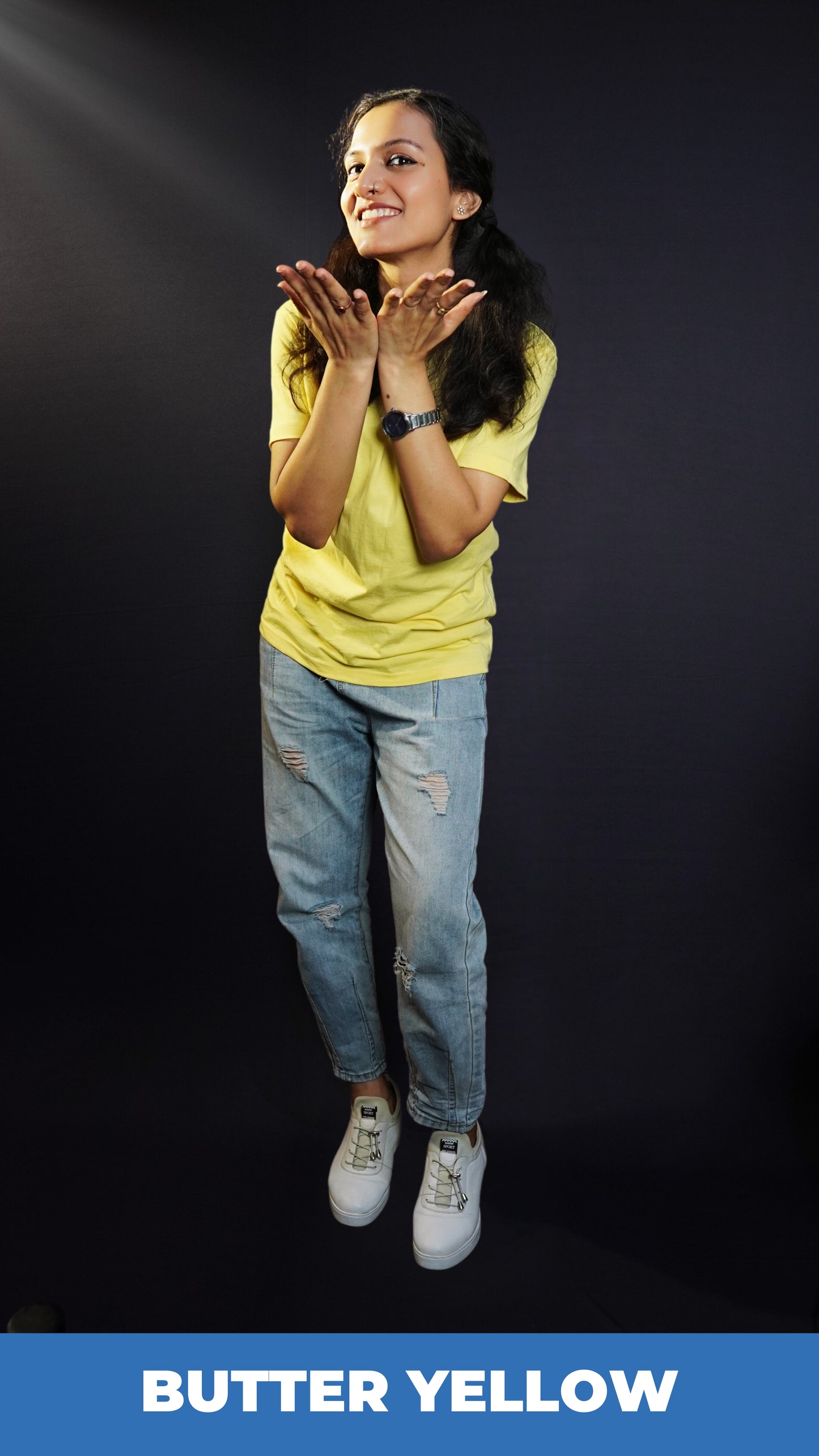 A woman posing happily with her hands directing forward, wearing a long length round neck plain adult's t-shirt, highlighting an elegant drapye look-Muselot