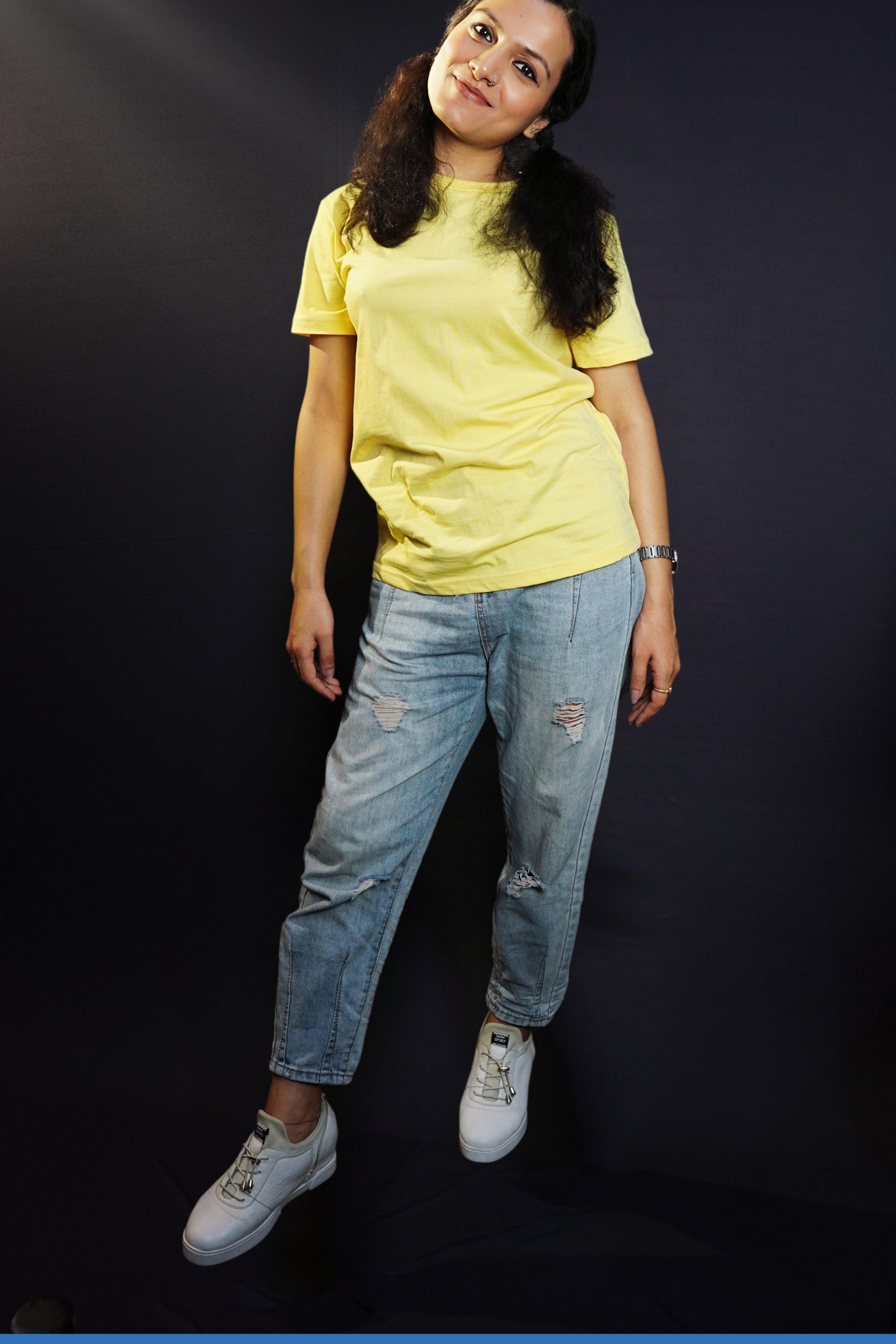 A woman posing as she slightly bend to her side, wearing butter yellow plain quick drying t-shirt, highlighting a cool breathable fit-Muselot