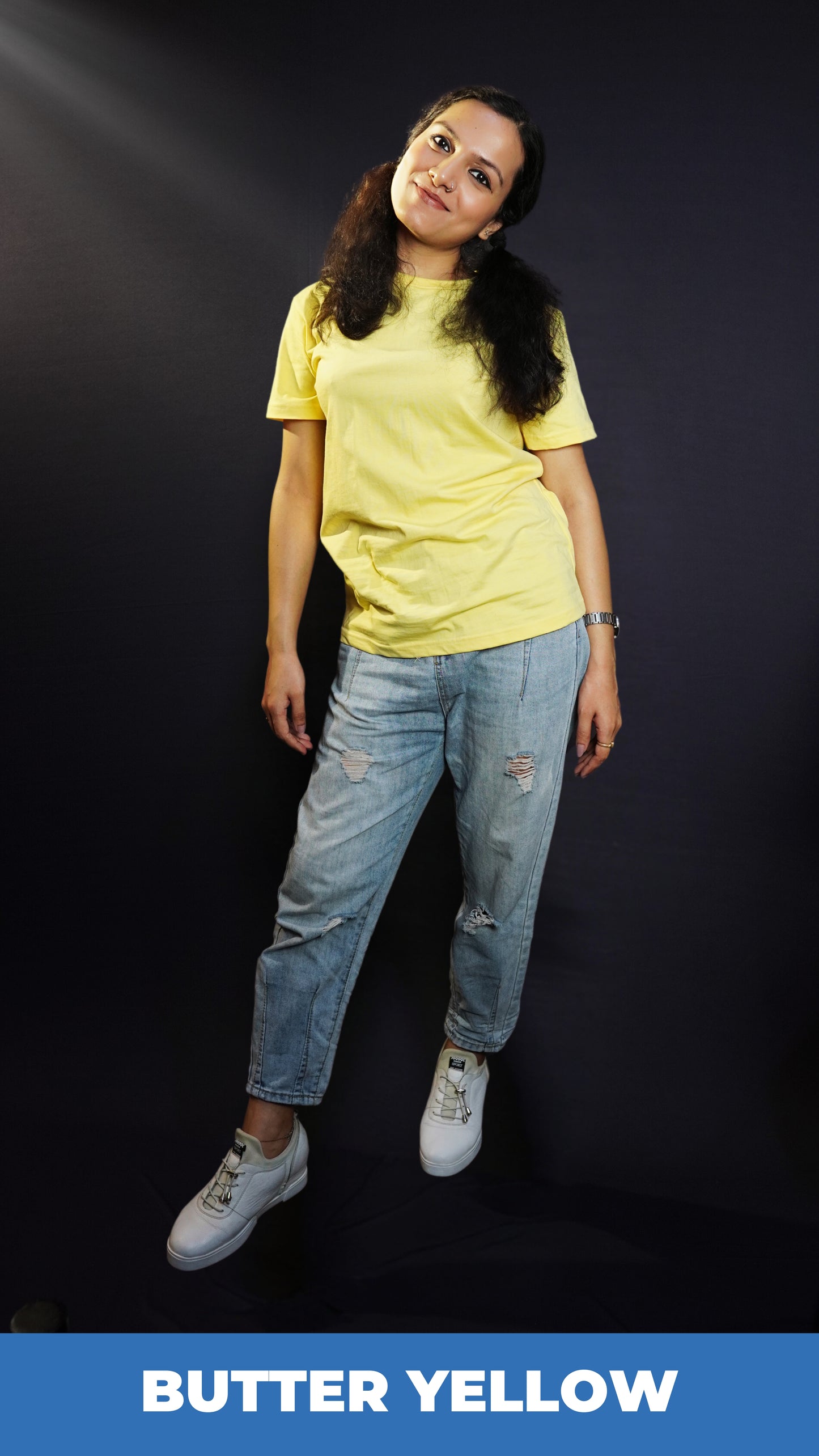 A woman posing as she slightly bend to her side, wearing butter yellow plain quick drying t-shirt, highlighting a cool breathable fit-Muselot