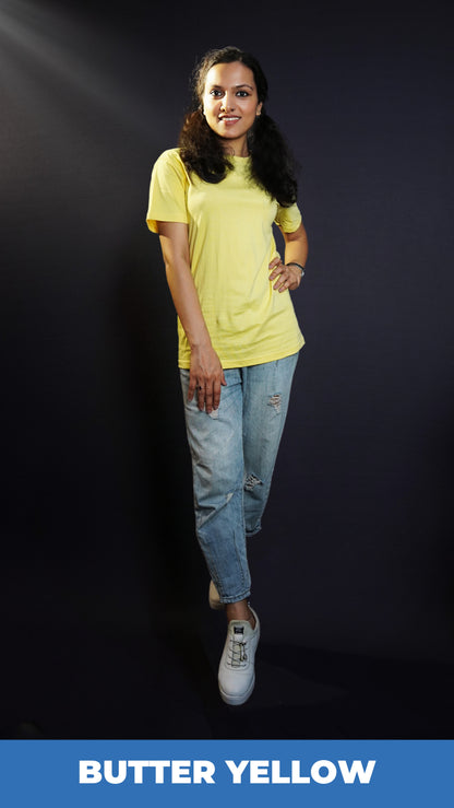 A model posing confidently as her hand relaxes on her thigh and another placed on her waist as she stands slightly sideway in a cool butter yellow round neck plain t-shirt, showcasing a cool comfortable look-Muselot