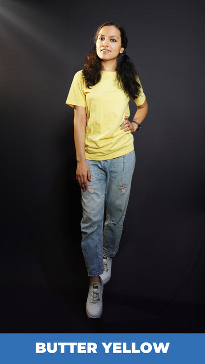 A classy model posing confidently as she places a hand on her waist and the other gently on her thigh, wearing a short sleeved plus size moisture wicking butter yellow t-shirt, highlighting a trendy everyday look-Muselot