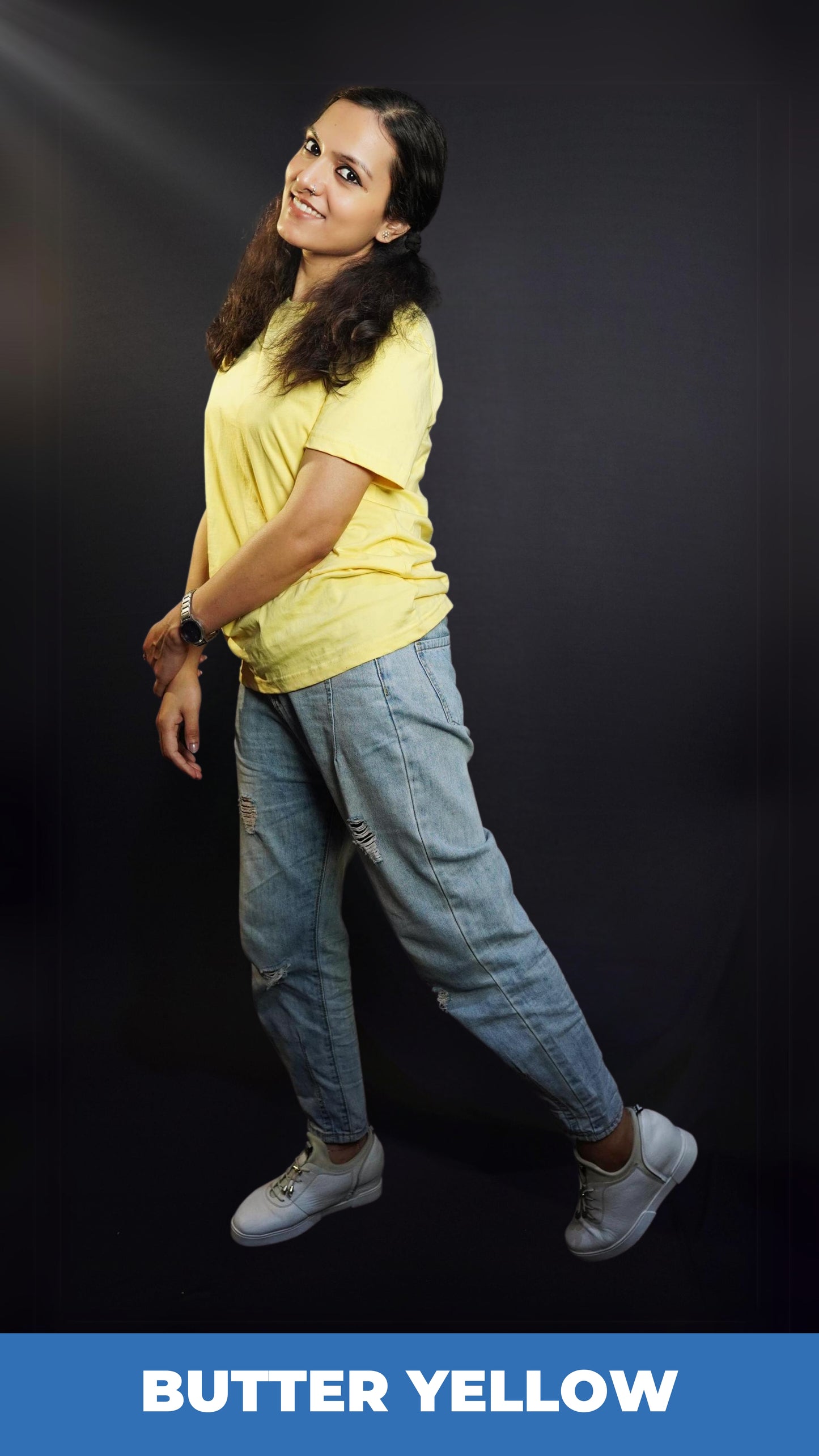 A woman posing happily as she sways sideways, wearing a butter yellow long length plain round neck t-shirt, highlighting a casual cozy look-Muselot