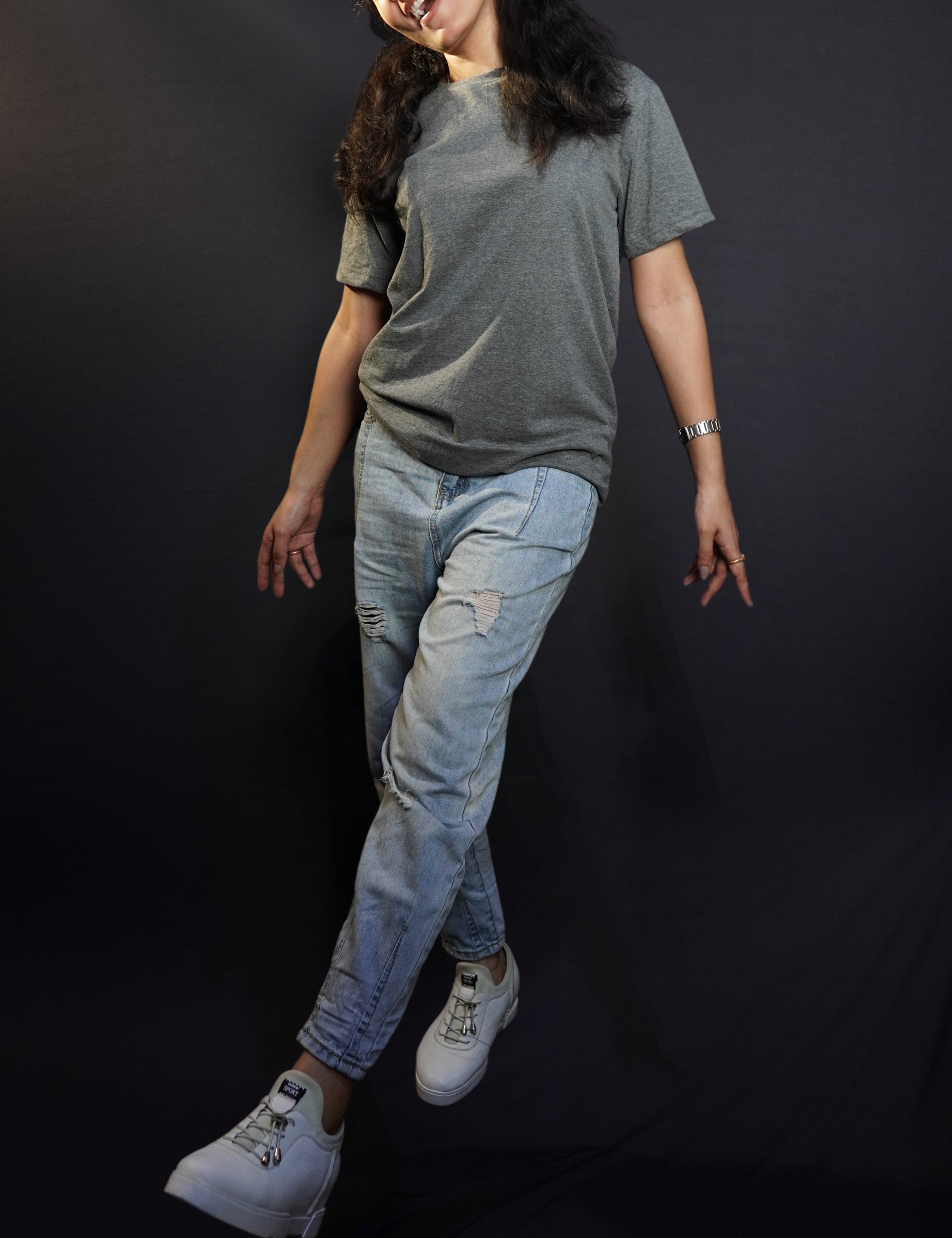 a woman wearing charcoal grey plain t shirt and ripped jeans walking and singing happily-muselot
