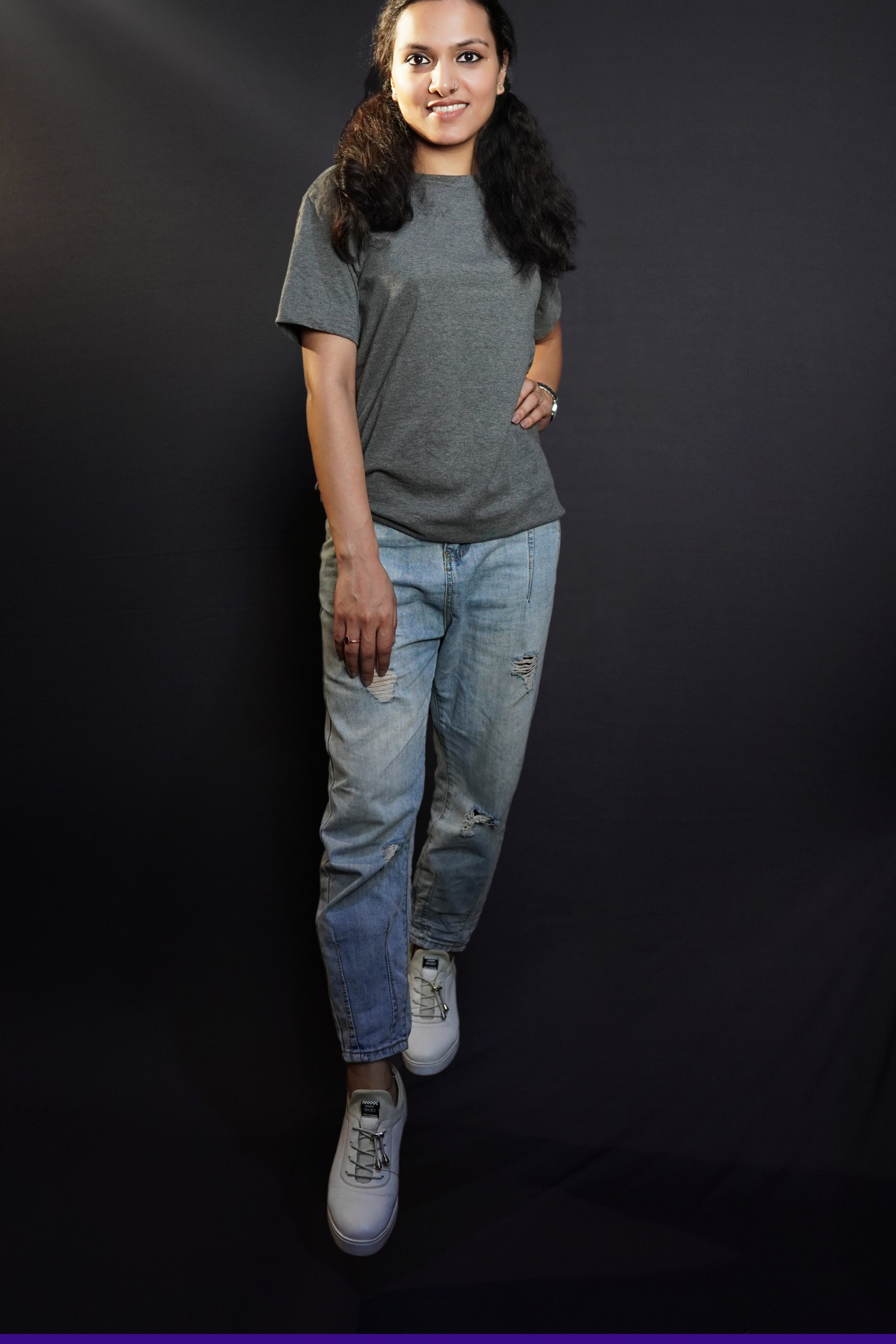a stylish model posing confidently in round neck stretchable plain t shirt looking directly at the camera with a smile on her face-muselot