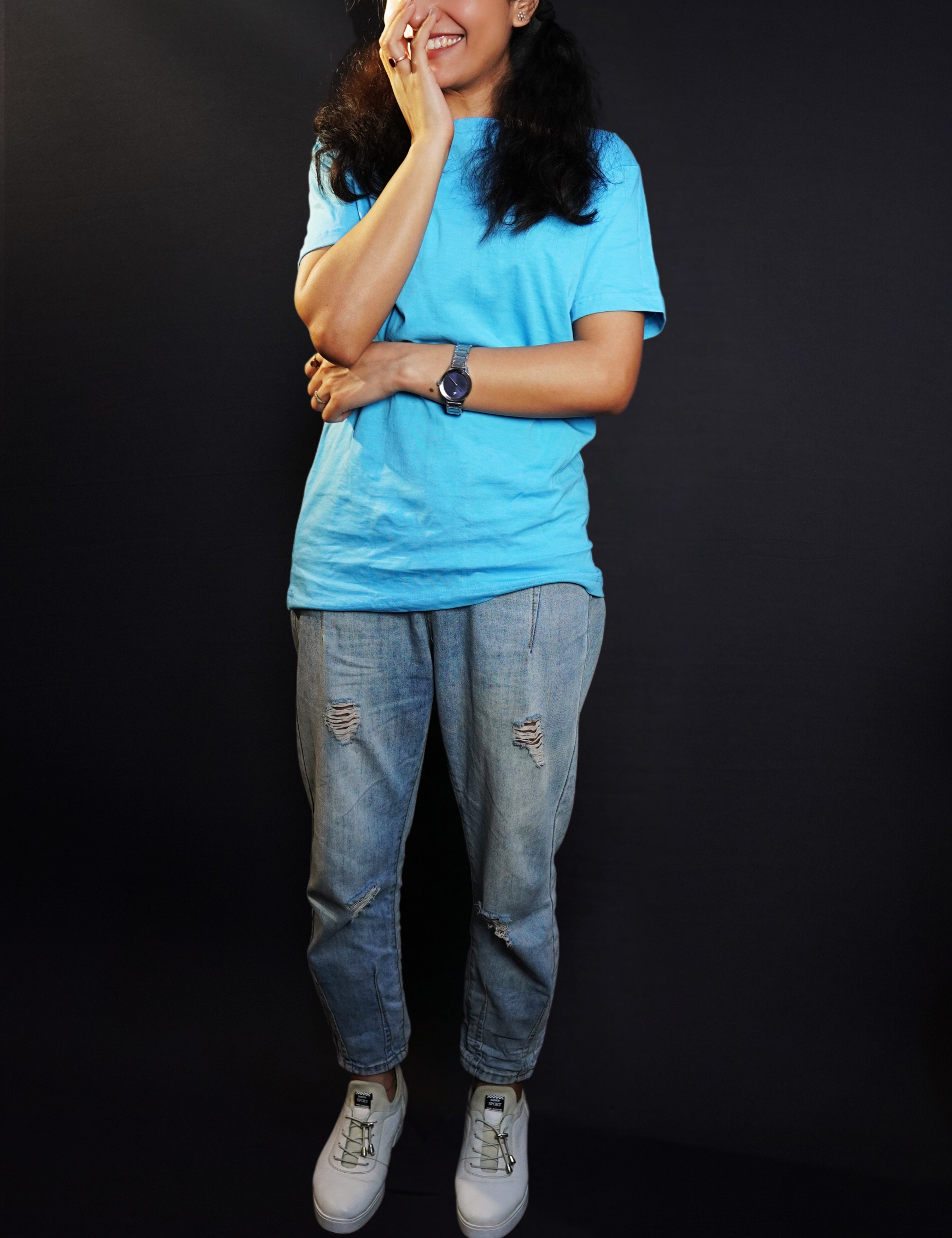 A woman laughing with her hand on the side of her mouth, wearing a cool summer short sleeved stretchable unisex cloudless blue t-shirt, showcasing a relaxed snug fit-Muselot