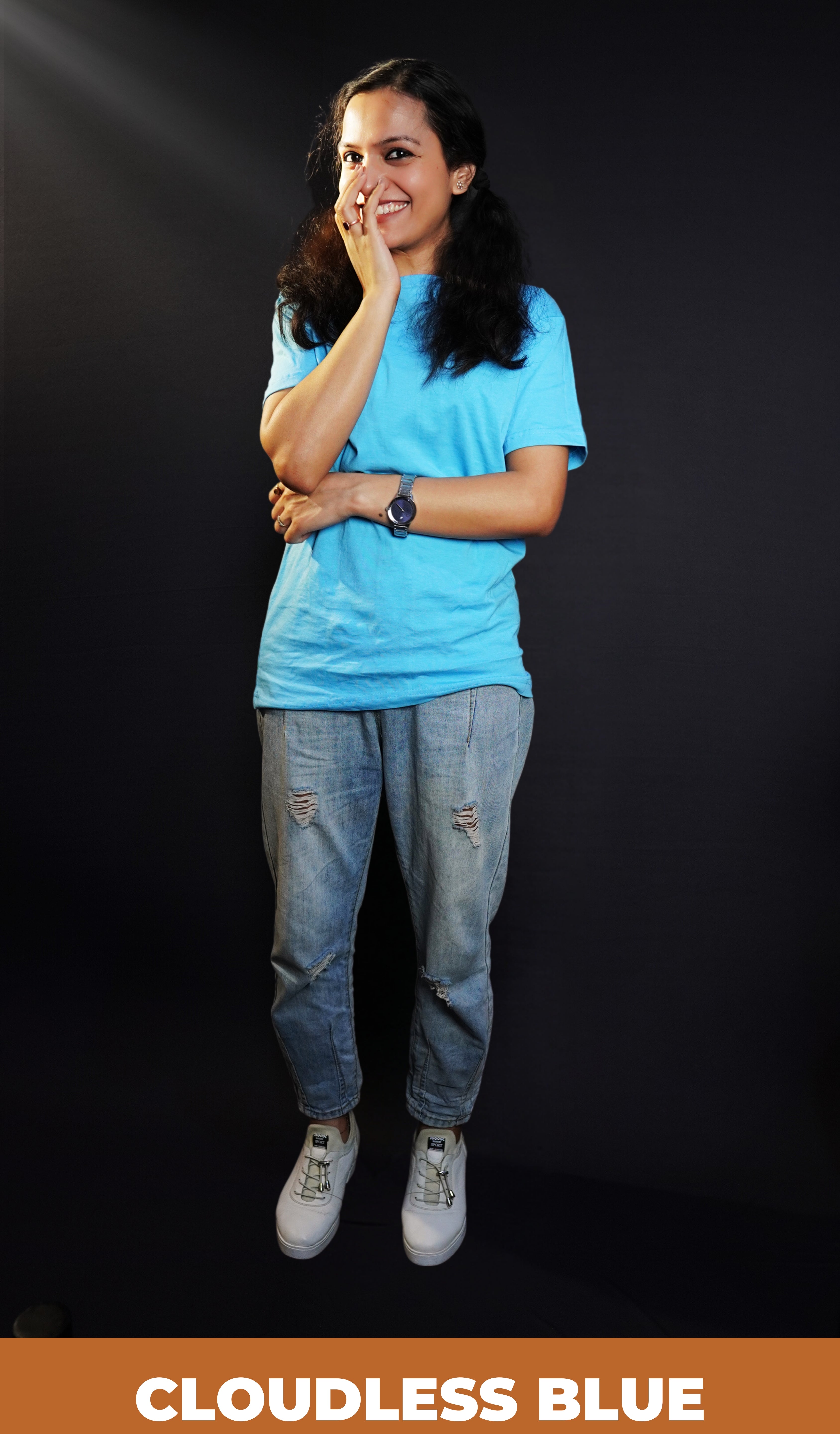 A woman laughing with her hand on the side of her mouth, wearing a cool summer short sleeved stretchable unisex cloudless blue t-shirt, showcasing a relaxed snug fit-Muselot