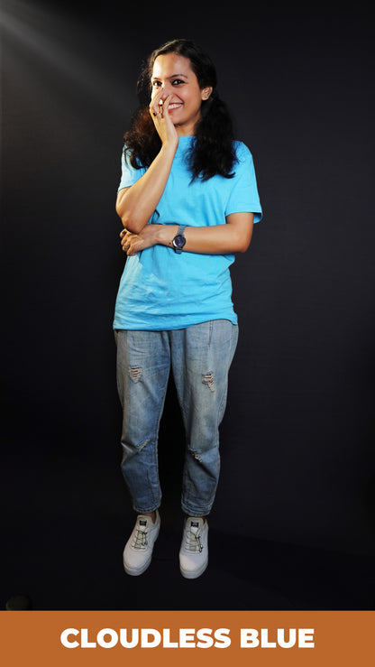 A woman laughing with her hand on the side of her mouth, wearing a cool summer short sleeved stretchable unisex cloudless blue t-shirt, showcasing a relaxed snug fit-Muselot