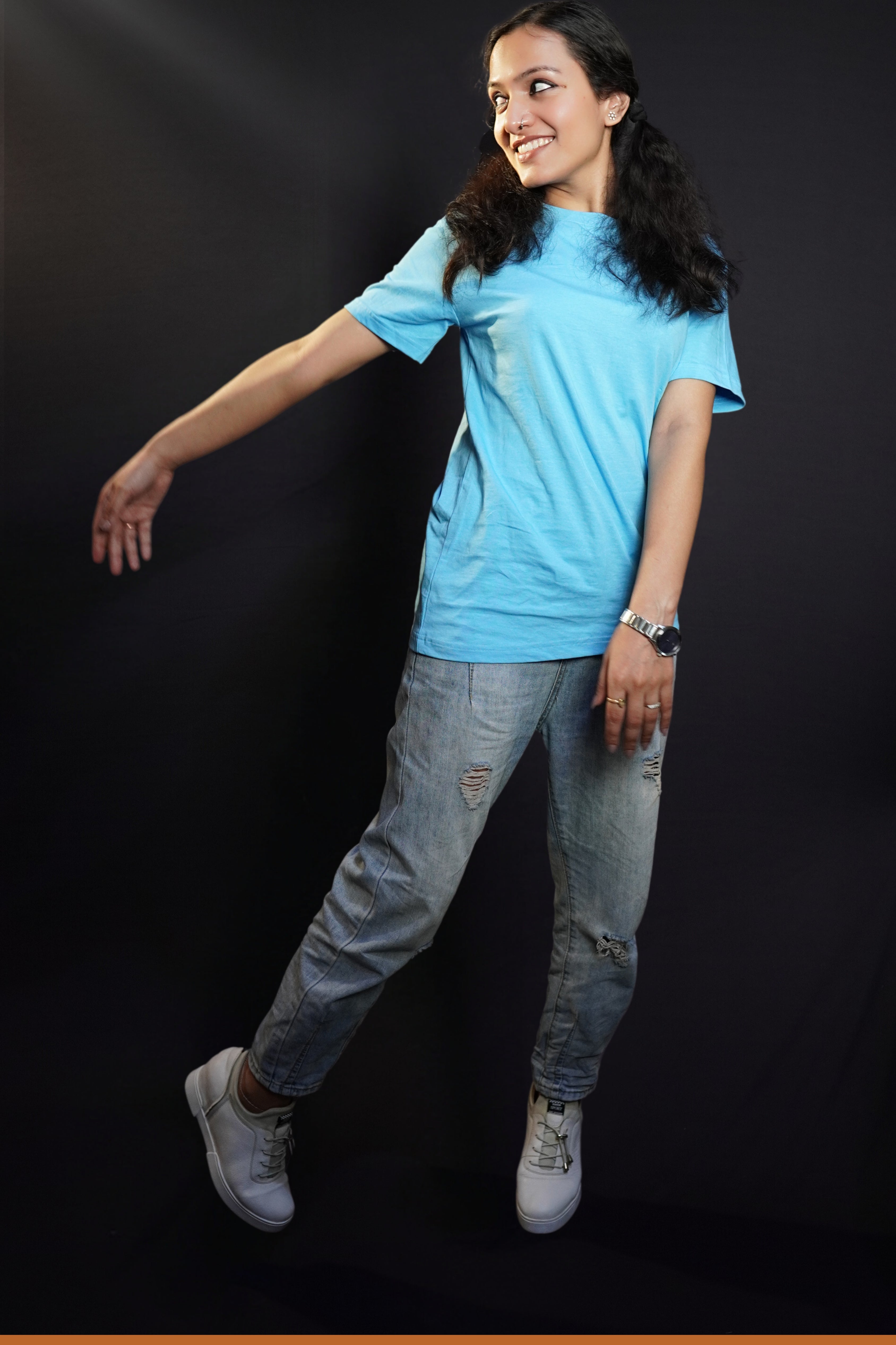 A short haired woman wearing a men's plus size plain t-shirt, standing with one hand swayed back, highlighting a cool slouchy fit-Muselot