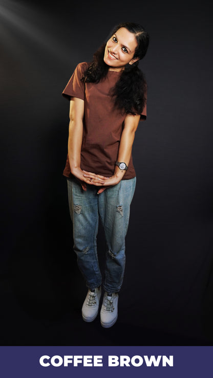 A woman wearing a short sleeved cotton coffee brown plain t-shirt, posing with her hands stretched and fingers intertwined, highlighting a fashionable casual fit-Muselot