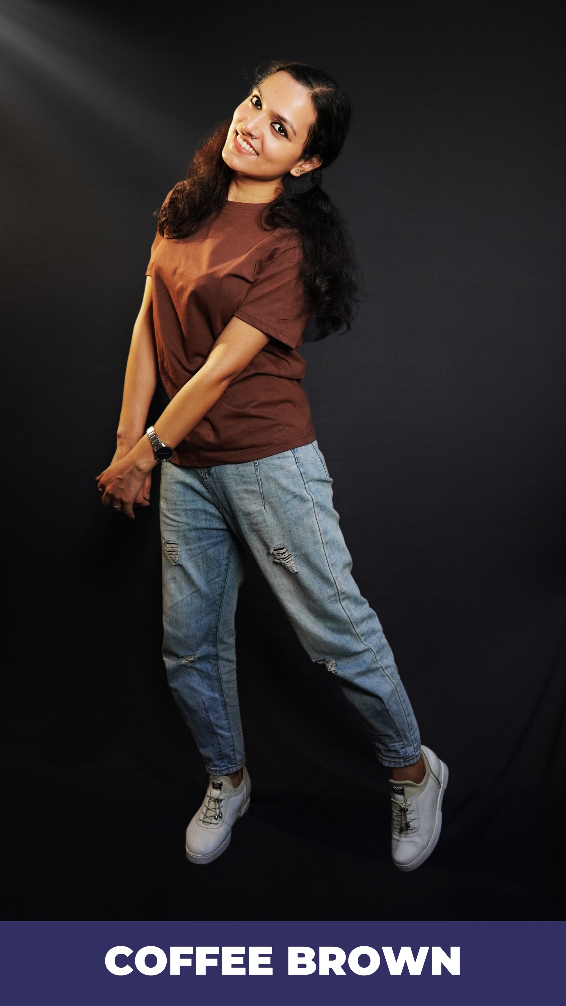 A woman posing happily as she sways sideways with her head bent backward, wearing a unisex stretchable round neck coffee brown t-shirt, showcasing a perfect fit style-Muselot