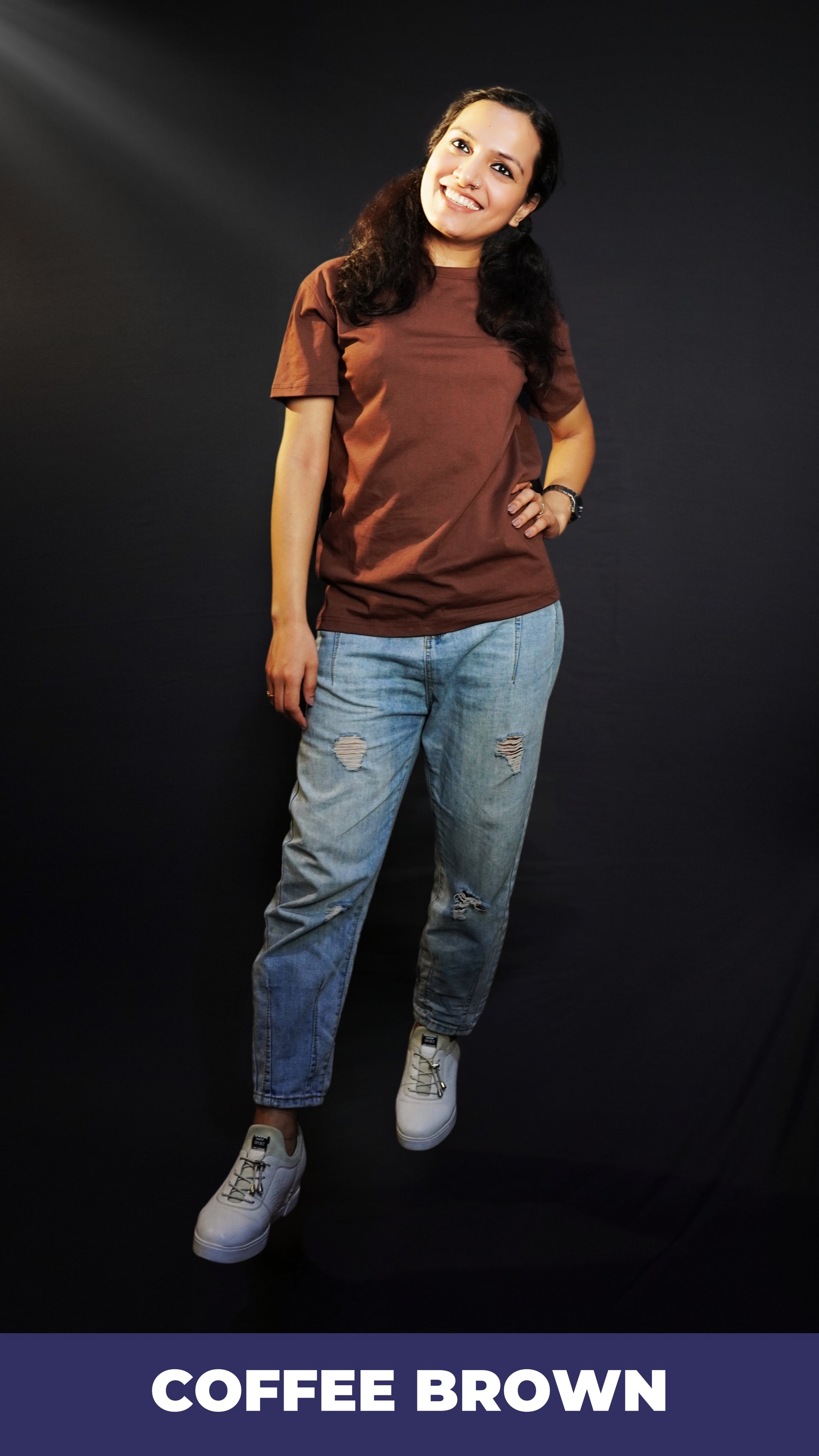 A stylish model posing with a smile and her hand on her waist, wearing a round neck short sleeved women's t-shirt, highlighting a easygoing fit-Muselot