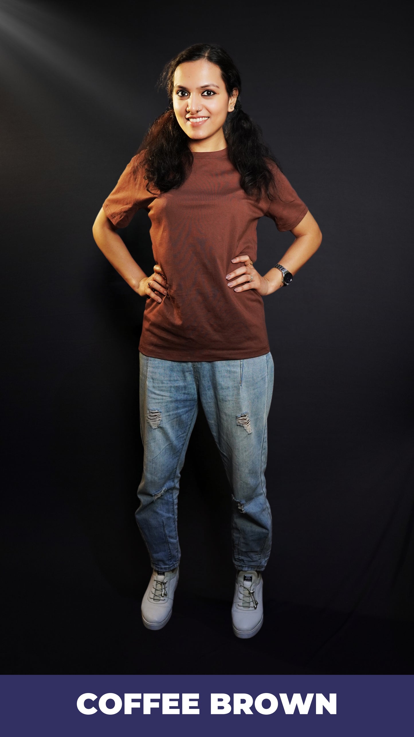 A woman wearing a long plain round neck coffee brown t-shirt, posing with her hands on the sides of her waist, showcasing a flowing voguish style-Muselot