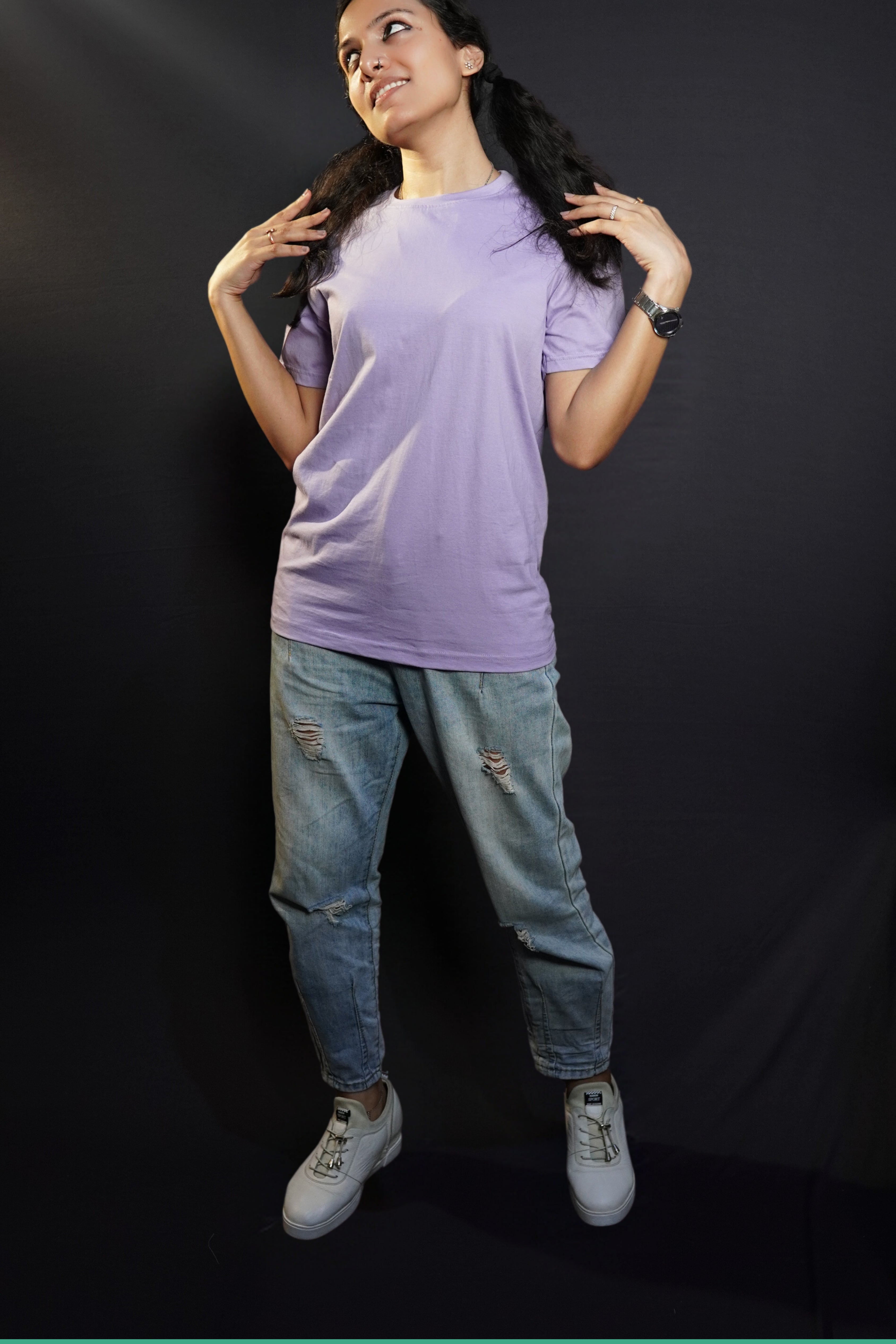 A woman wearing a plain adults round neck cotton gentle lavender t-shirt, posing with her short hair covering her shoulder and her hands sitting gently upon them, highlighting a stylish snug fit-Muselot