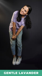 A woman smiling brightly wearing a short sleeved long length women's t-shirt, posing as she bends forward with her hands grabbing each other, highlighting a funky cool style-Muselot