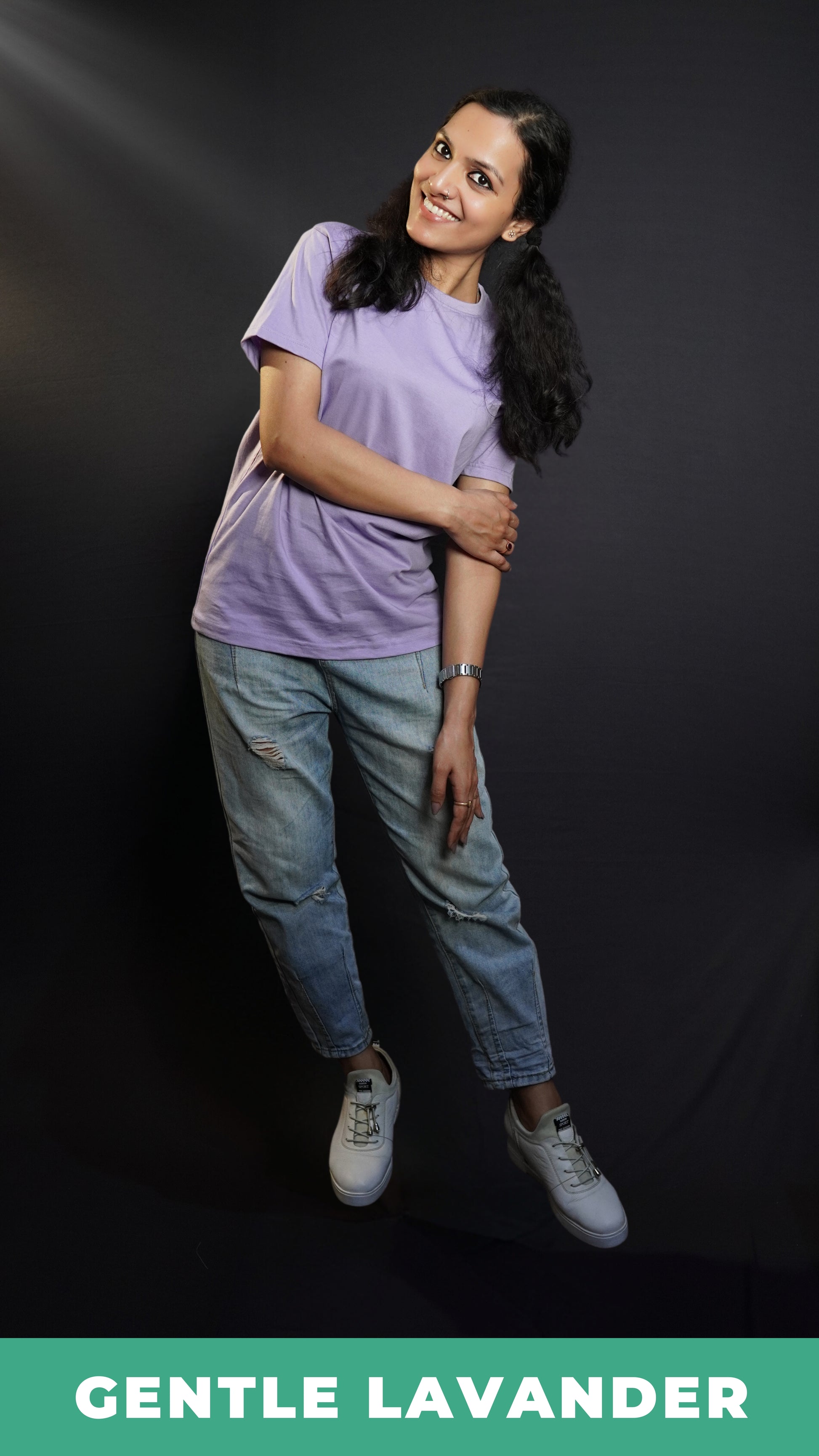 A woman wearing an adult's stretchable round neck short sleeved gentle lavender t-shirt, posing with her one hand grabbing her elbow, slightly bent to her side, highlighting a casual snug fit-Muselot